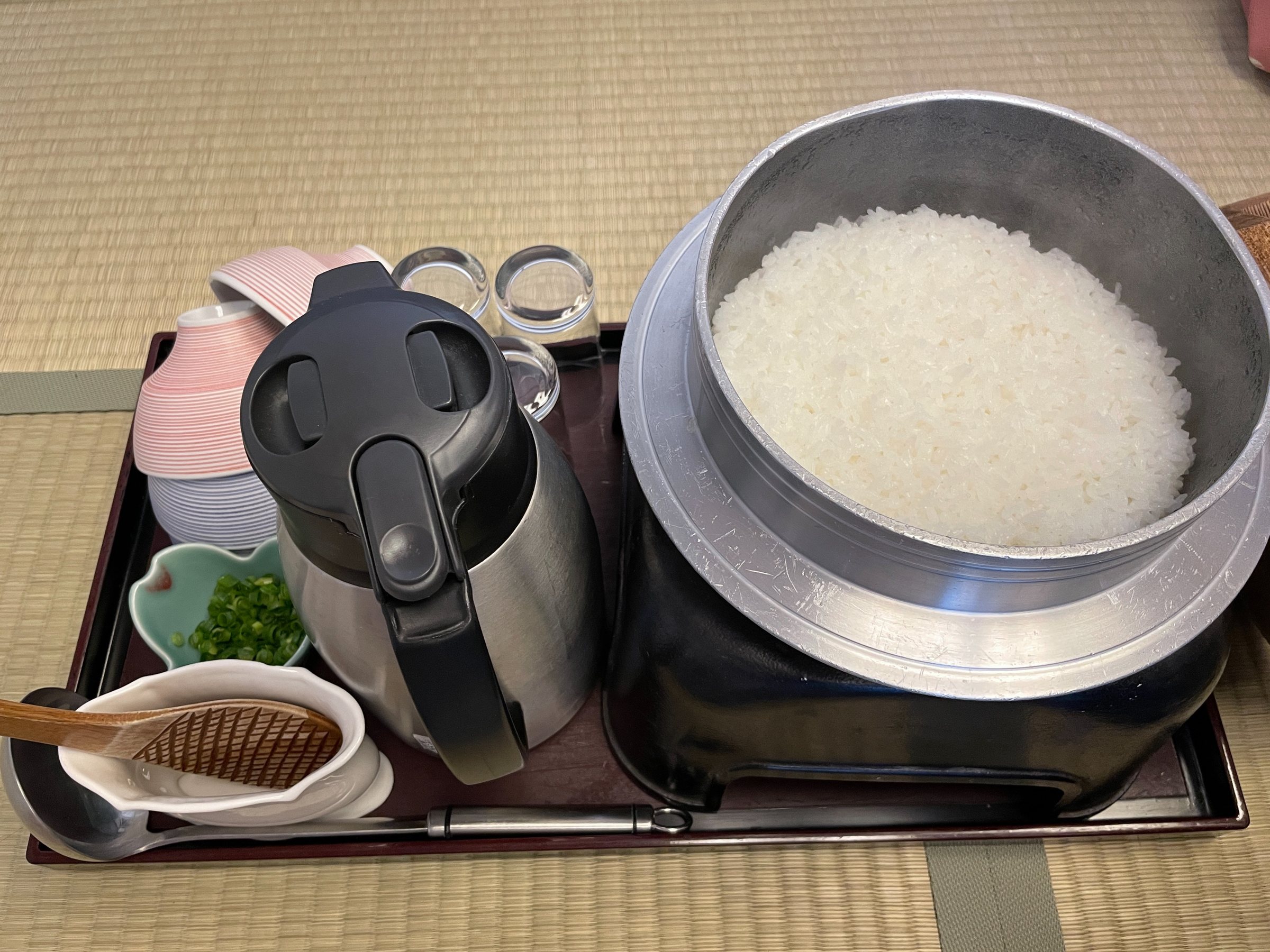 Rice cooked in a *kamado*-style pot, the wooden lid lifted.