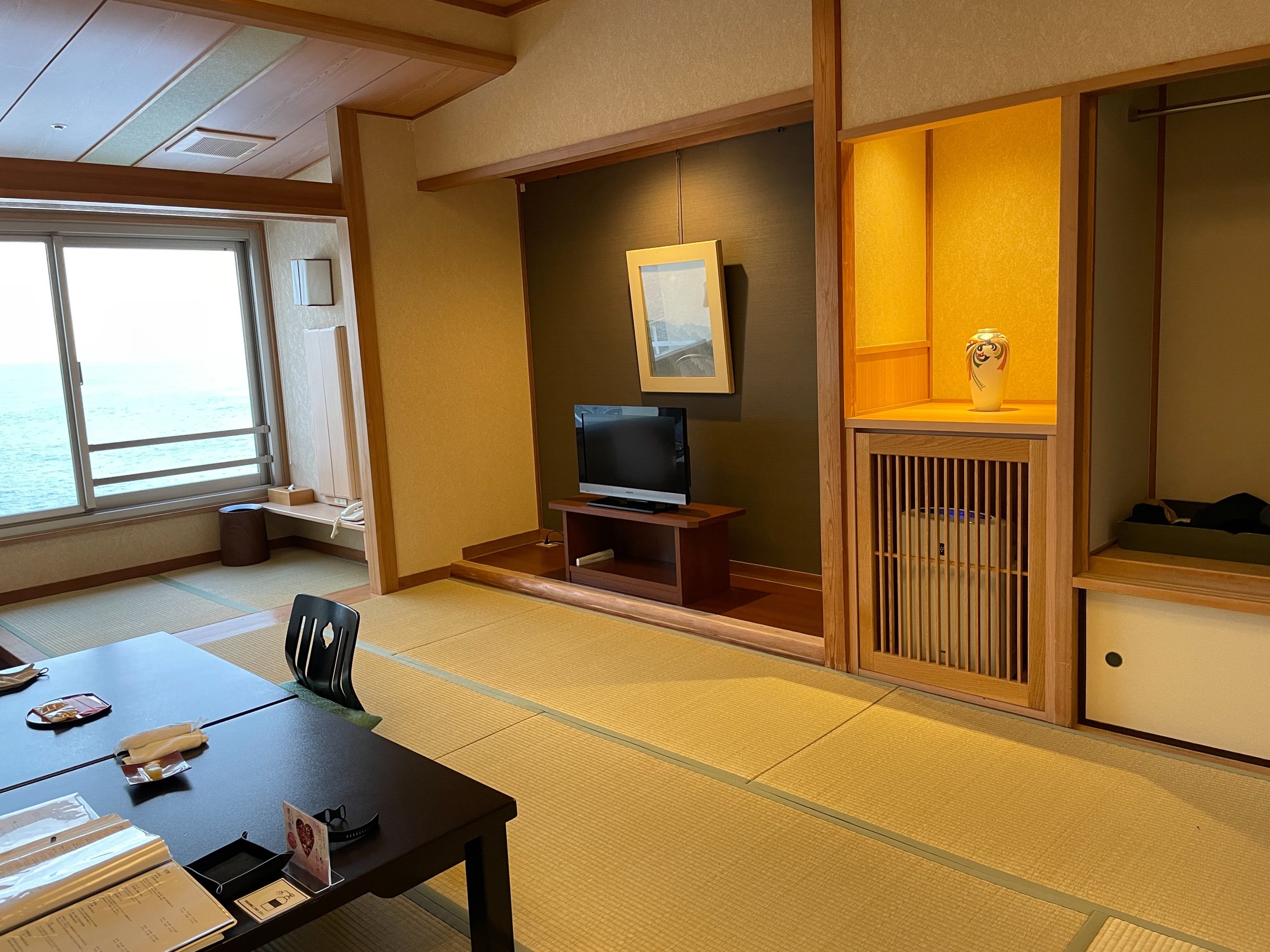 The tatami room, with a low table and the sea at the window.