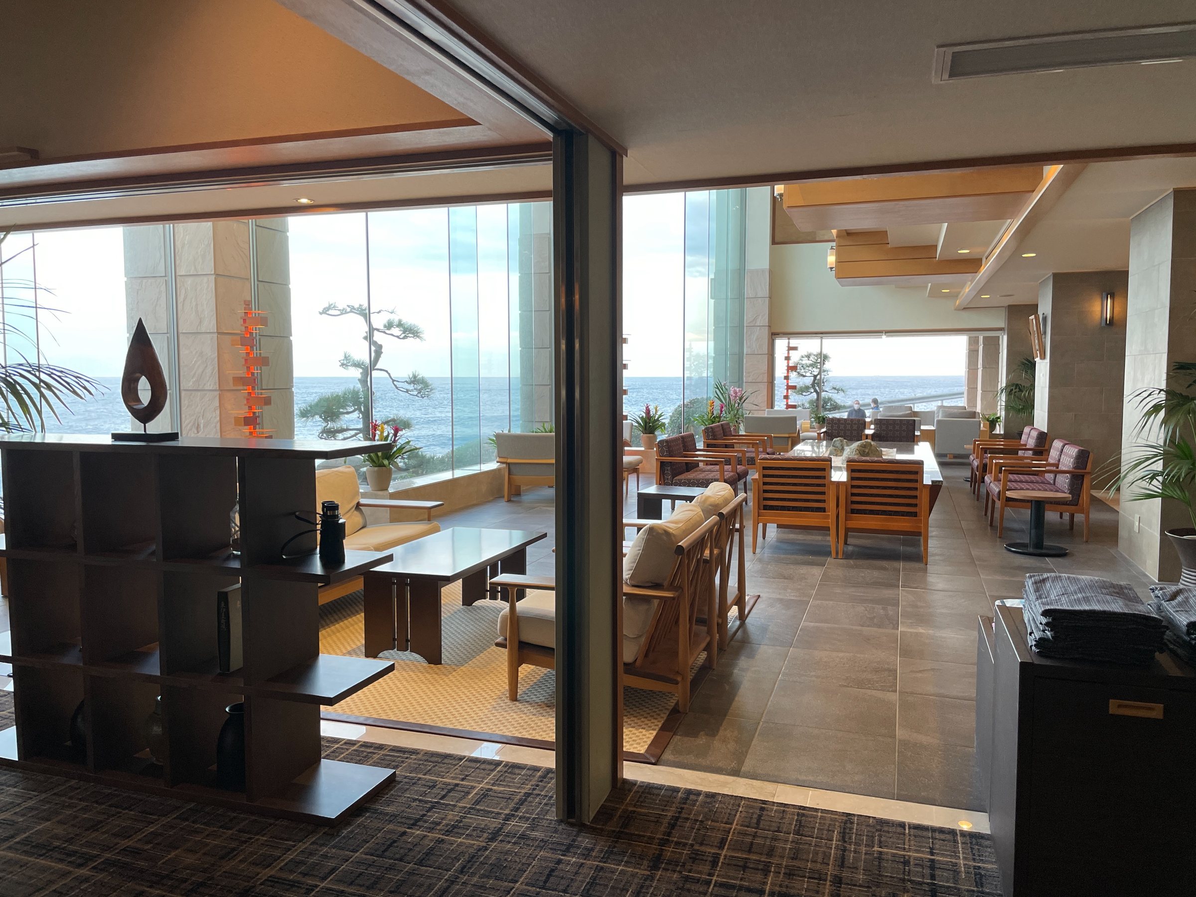 Lounge seating by the windows, the coast visible beyond.