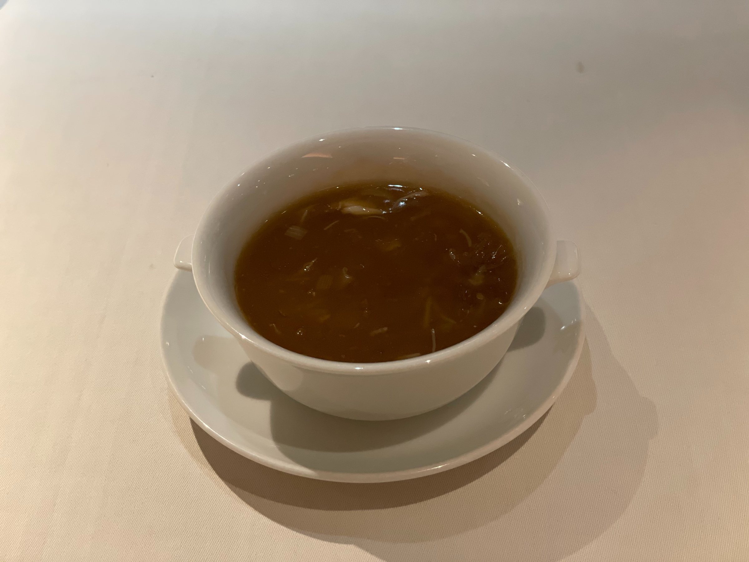 Shark fin soup, its thickened broth glossy and deep in color.