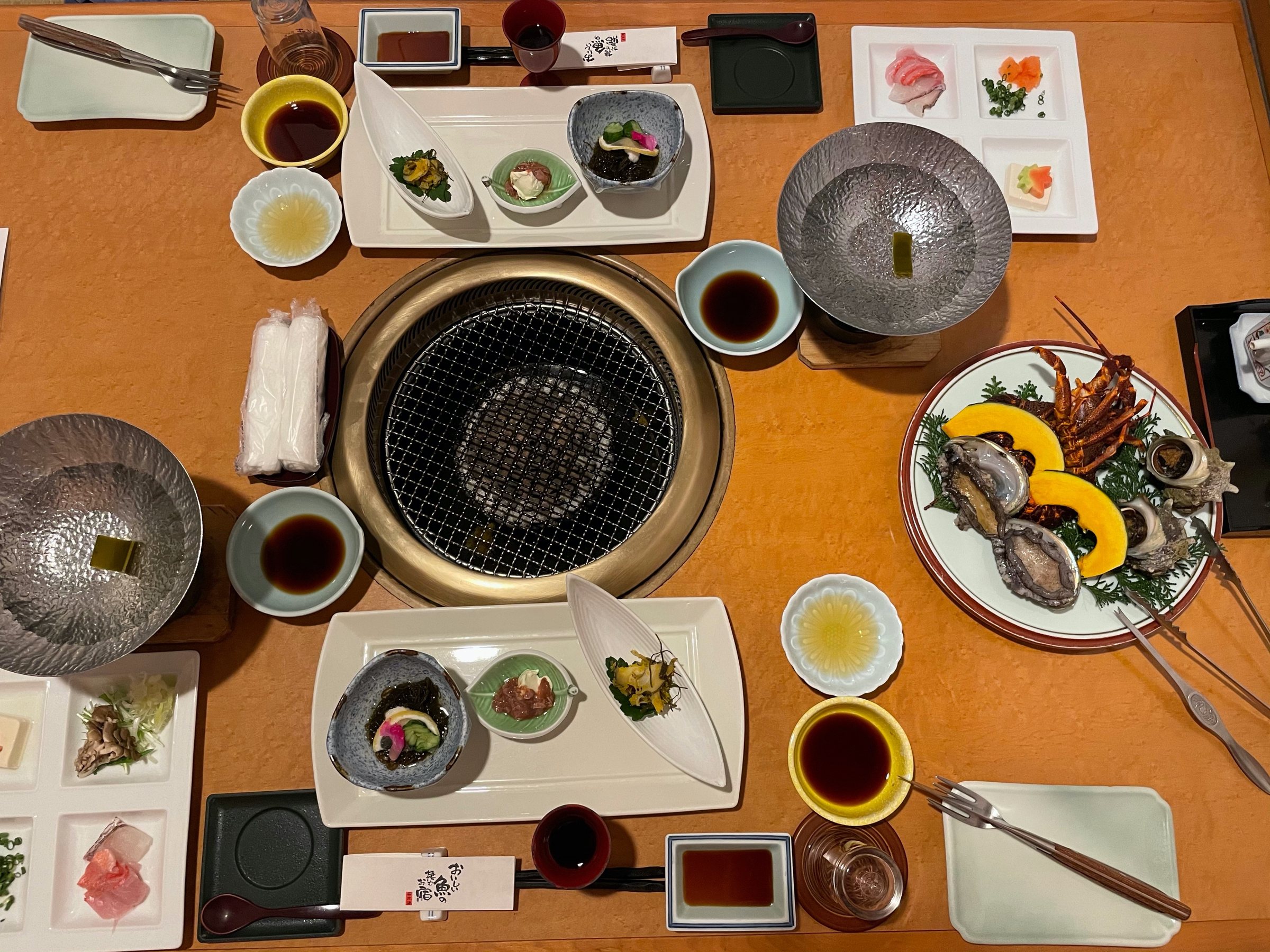 The table laid around its central grill.