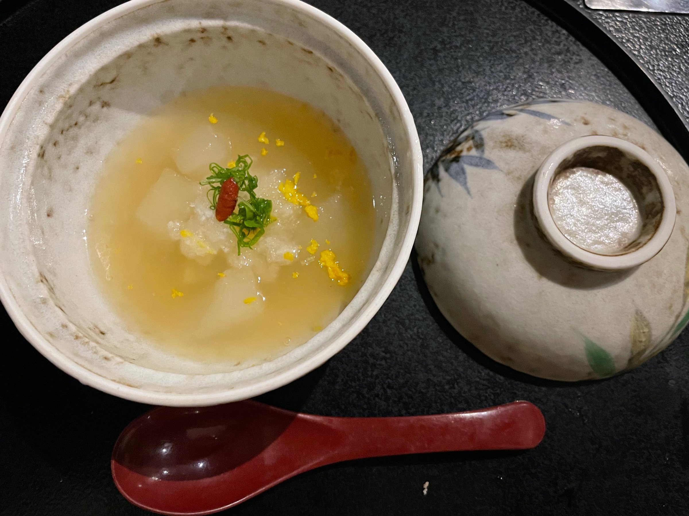 Winter melon in a softly thickened broth, scattered with yuzu.