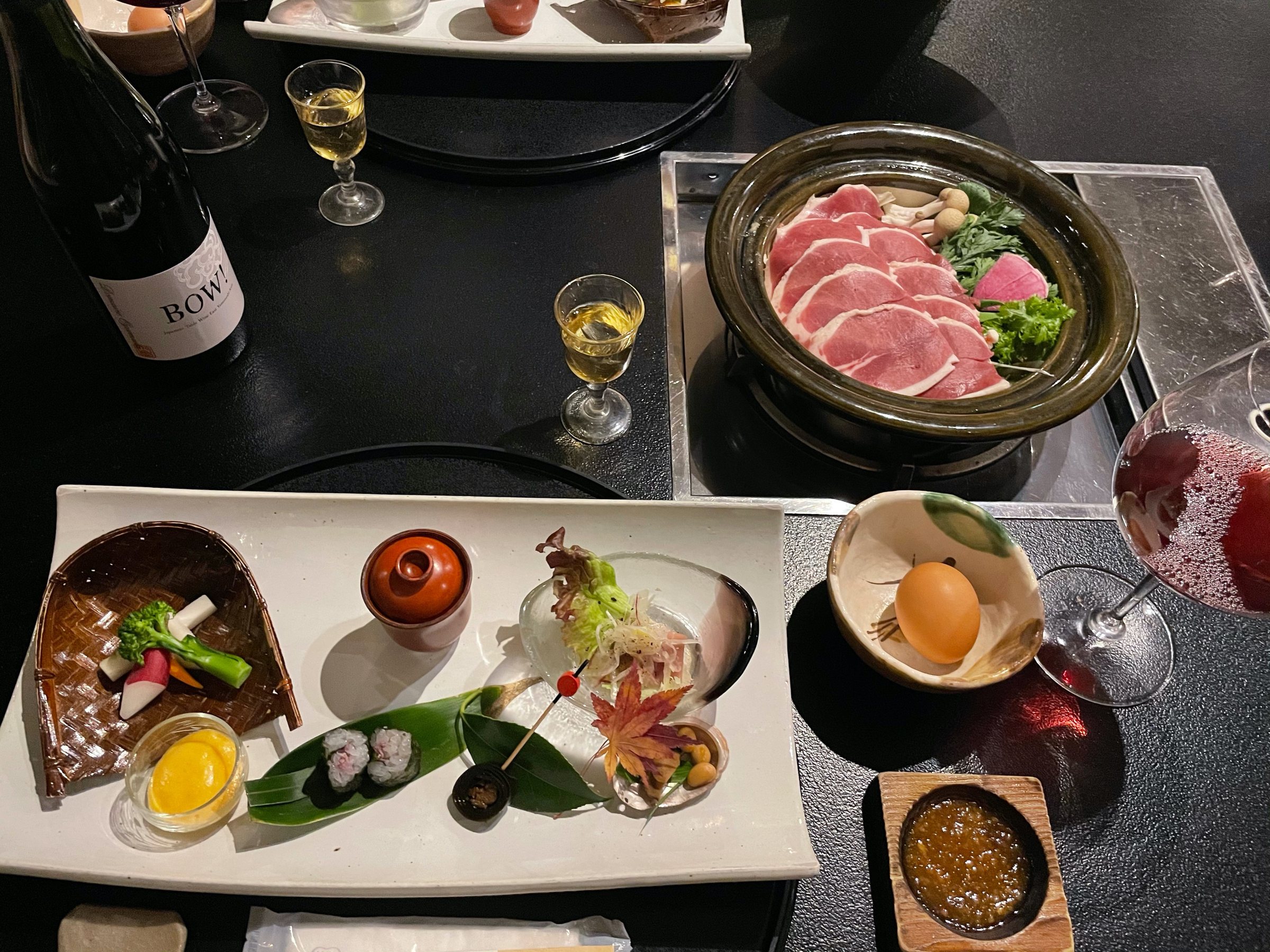 The dinner table, with duck for the hot pot and a glass of red.