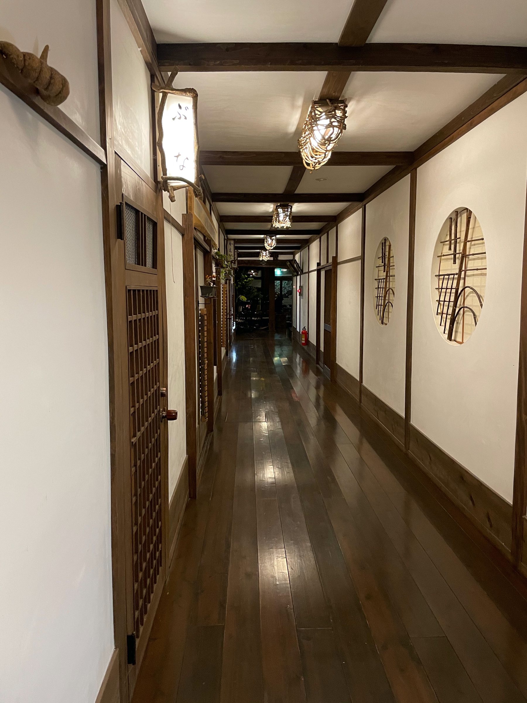 A long, polished corridor lined with lamps.
