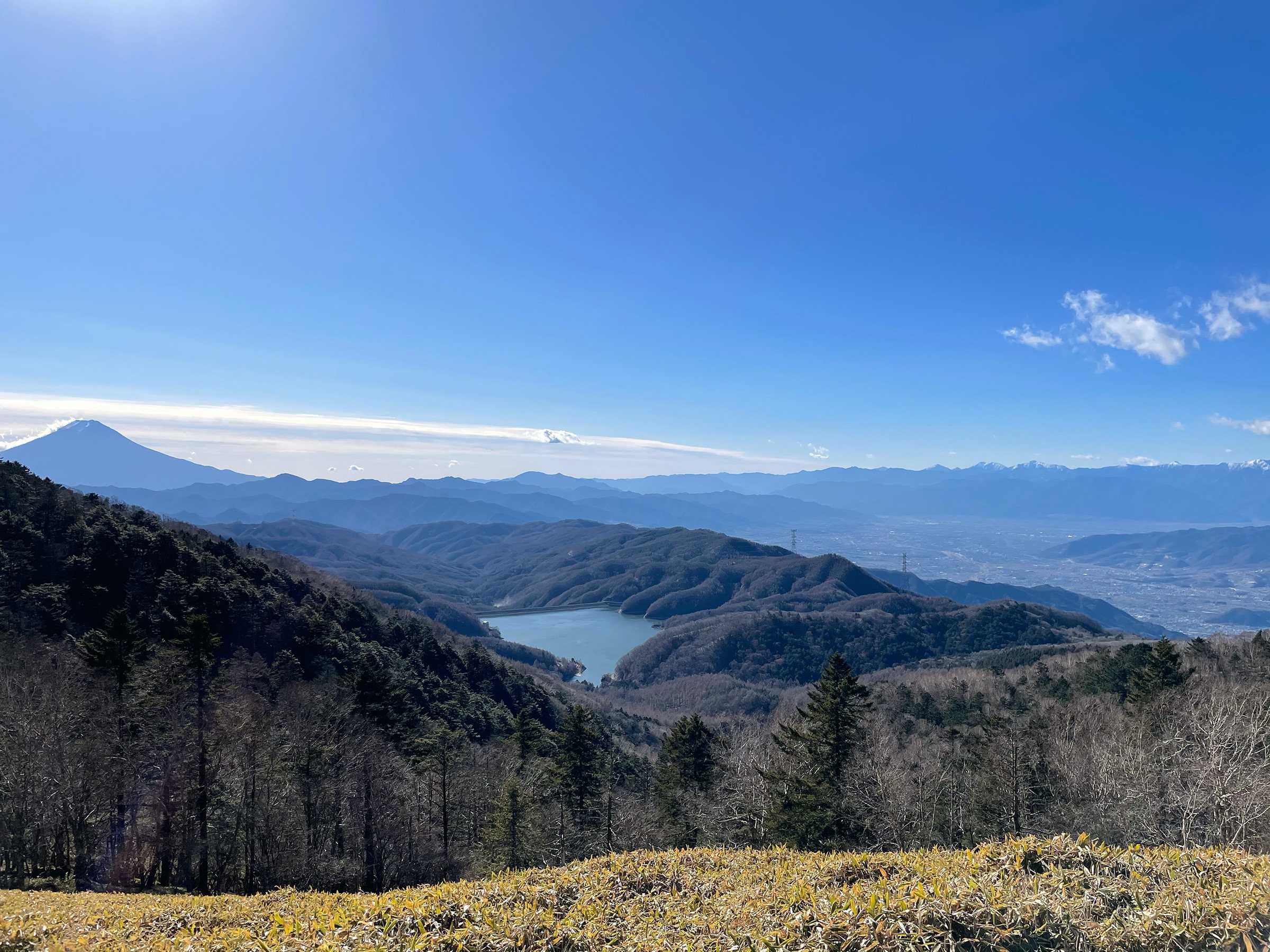 From the slopes of Daibosatsu: Mt. Fuji, a lake below and range upon range of mountains.