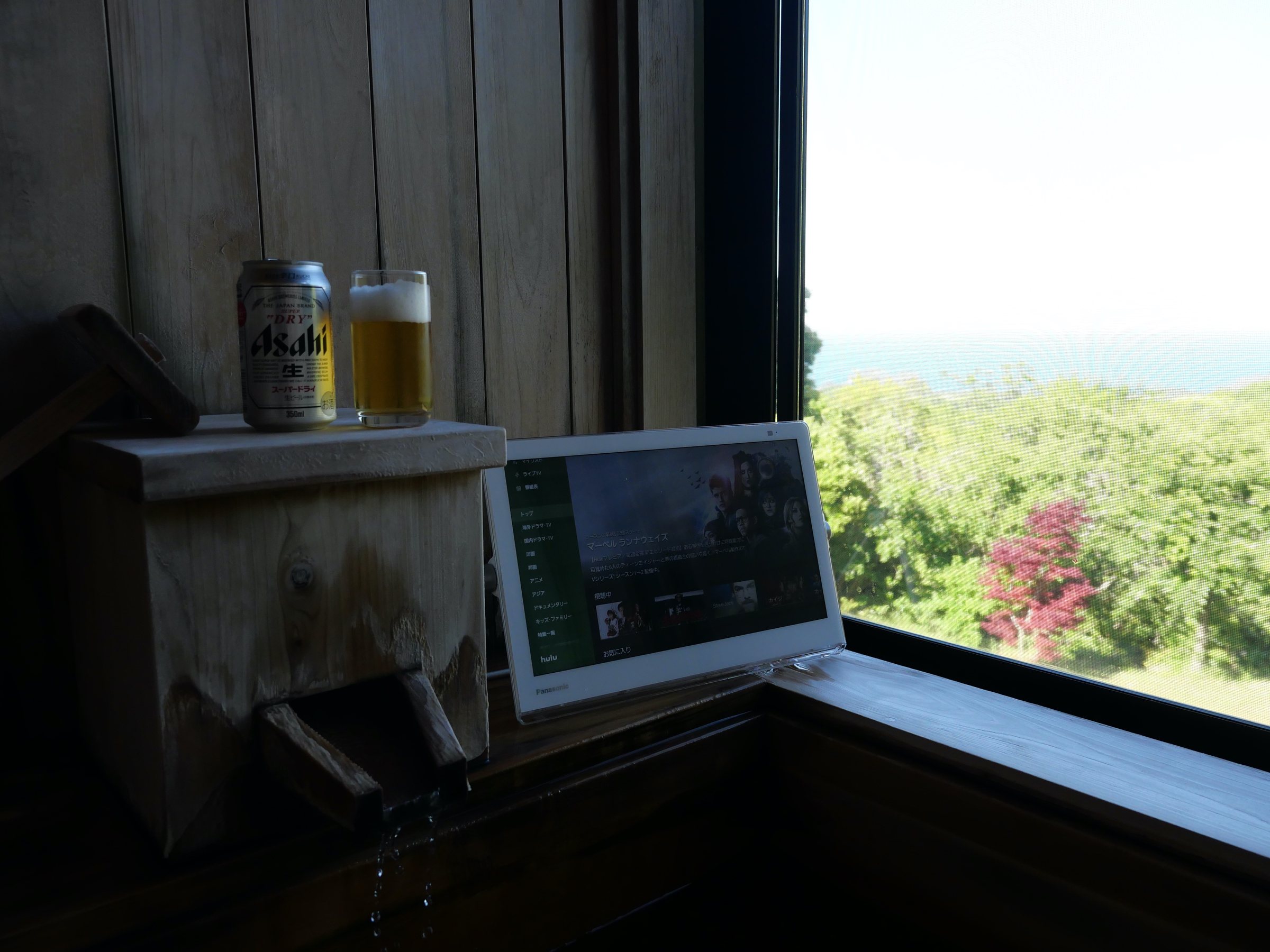 Beer, a waterproof screen and the sea beyond: our own small villa ritual.