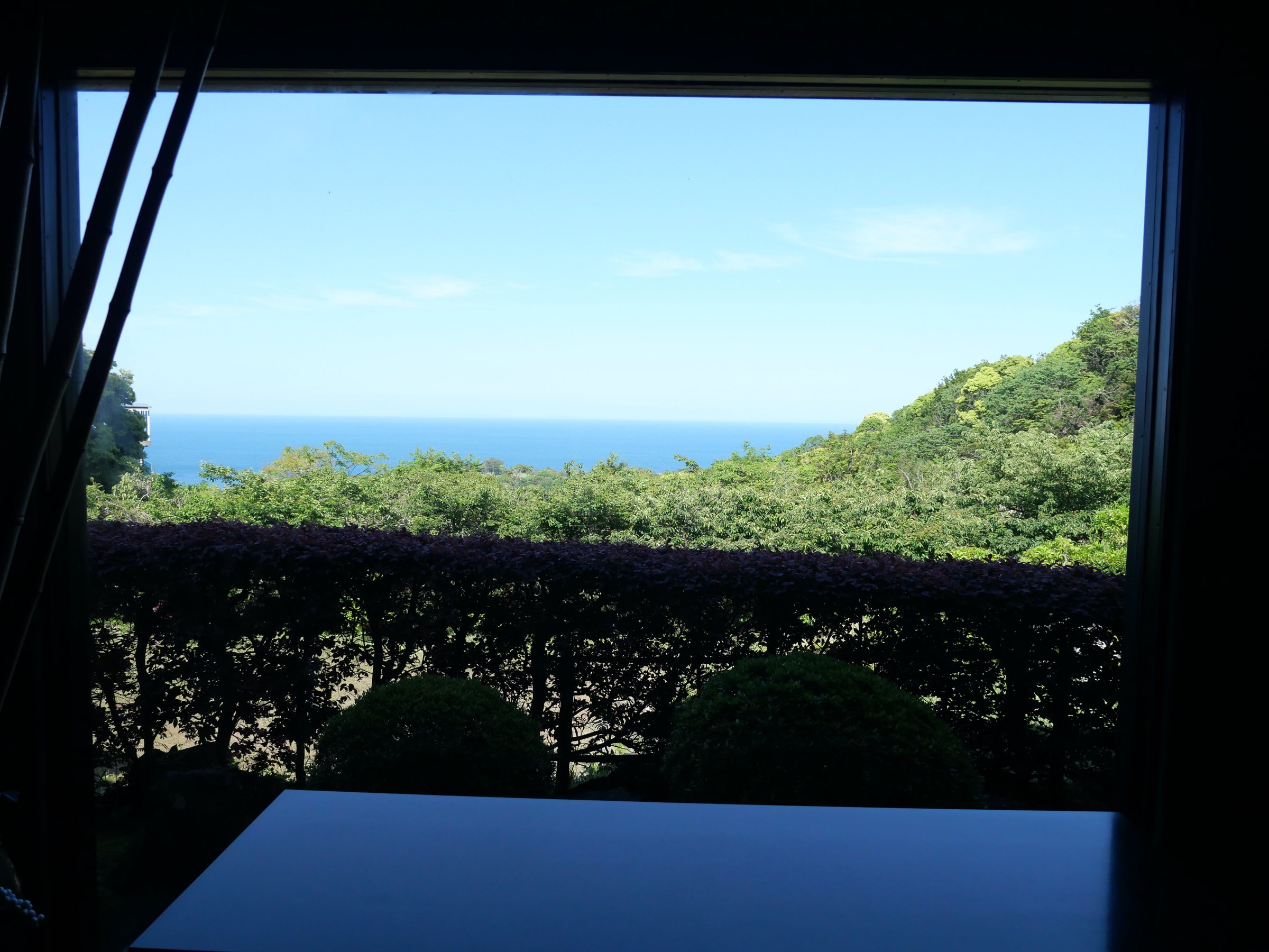 Sagami Bay, framed by the window above a band of green.