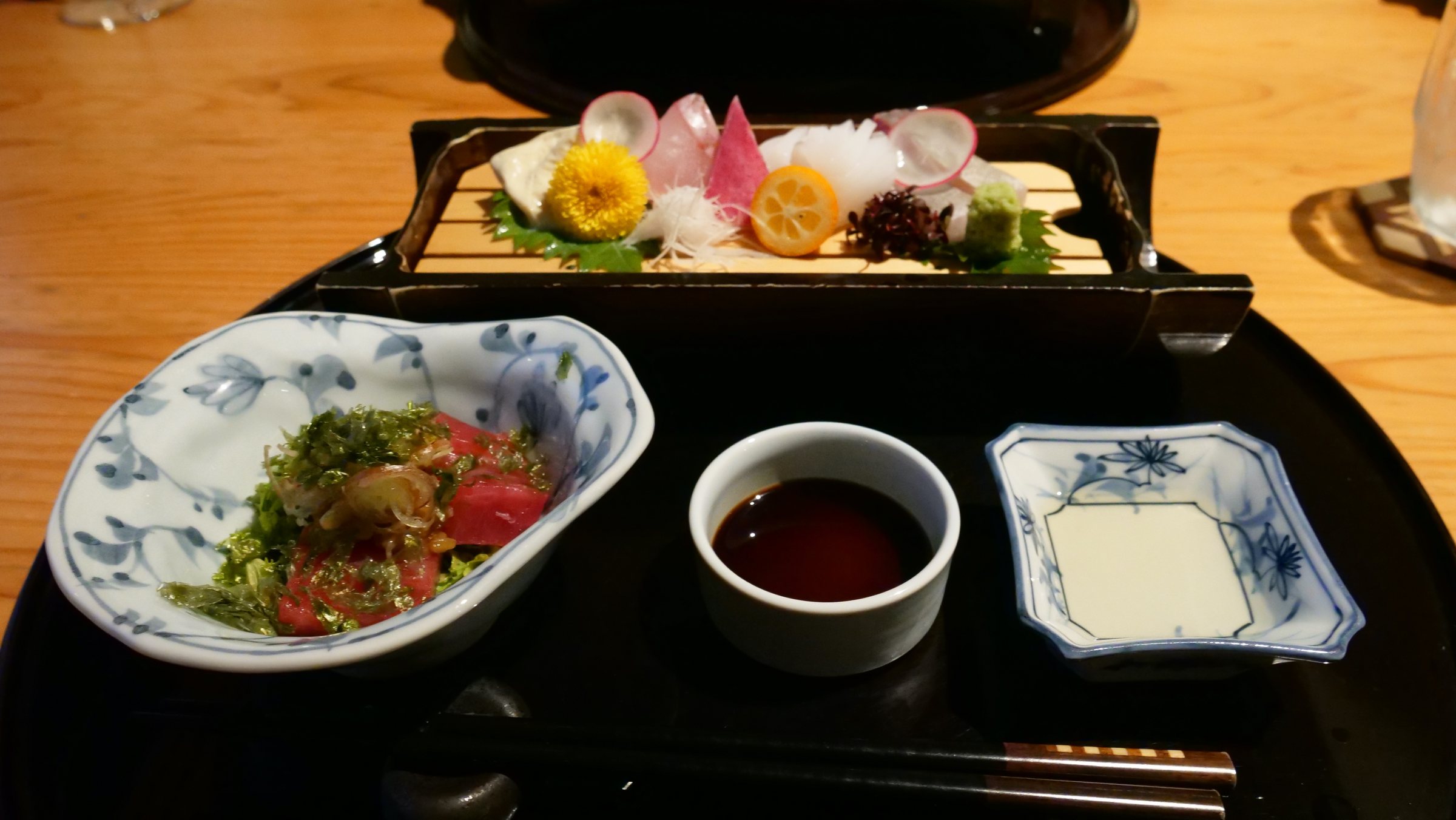Sashimi, with flowers and a small dish of soy sauce.