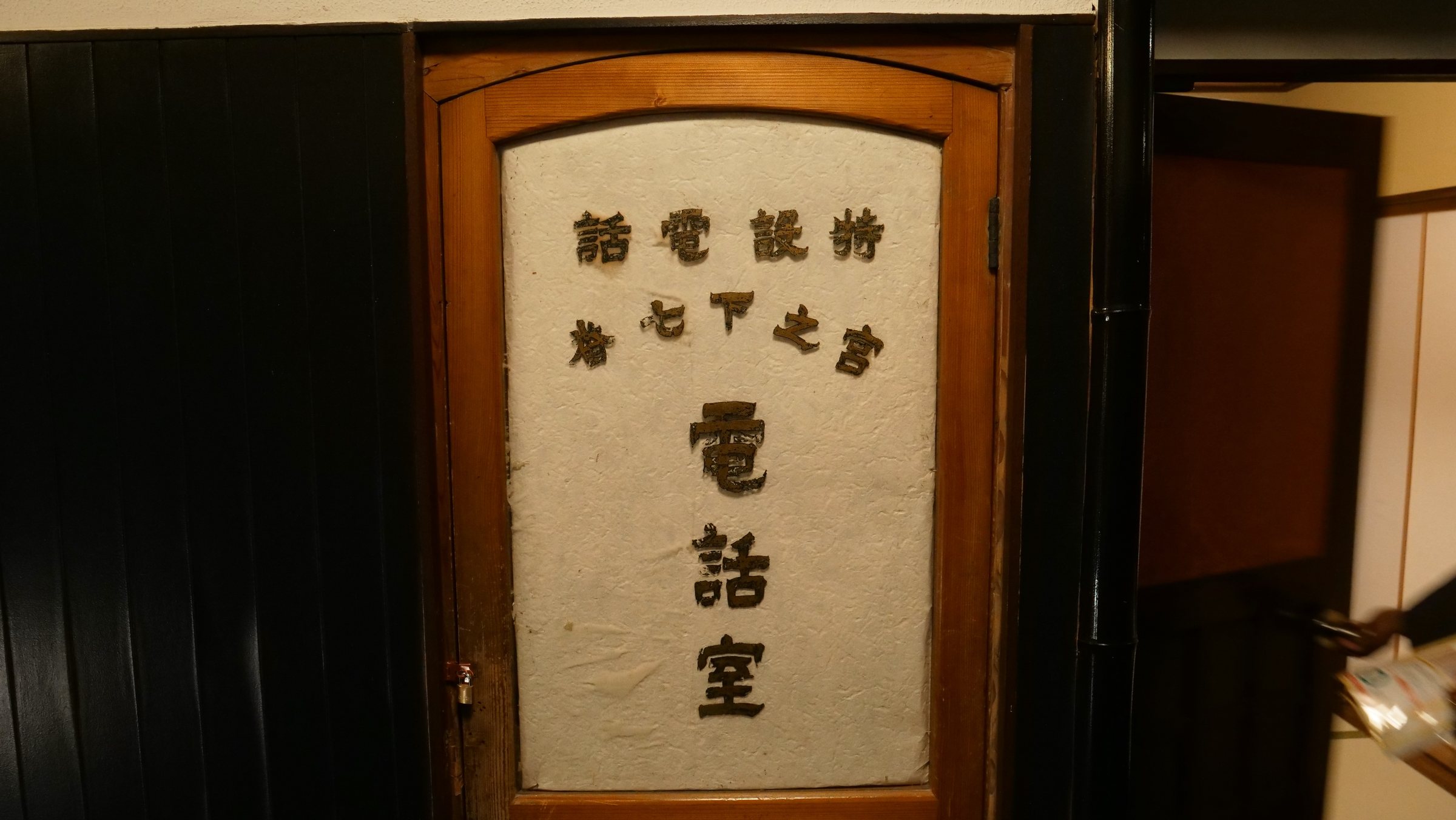 An old wooden door marked as the telephone room.