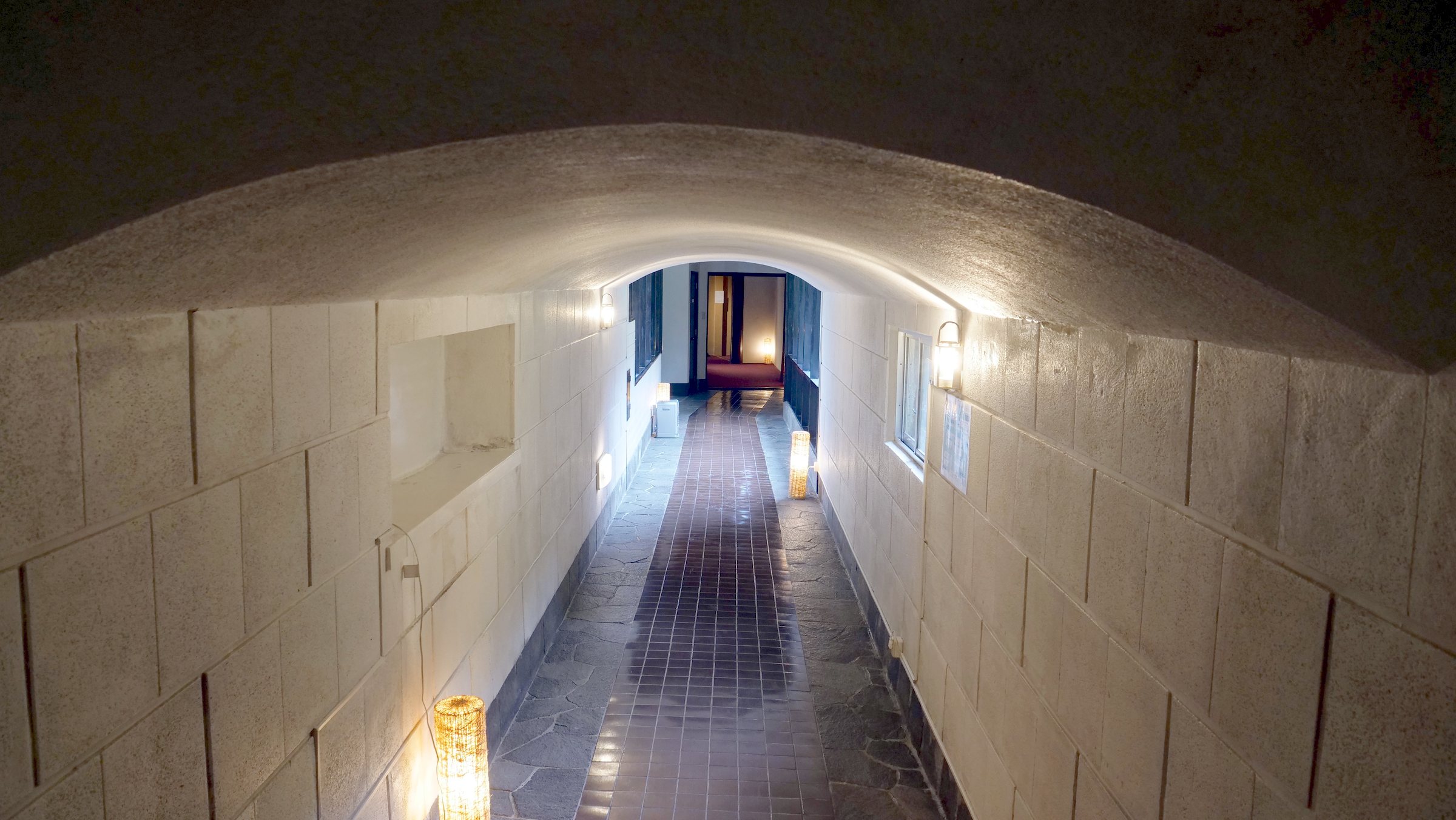 The vaulted, storehouse-style corridor, lit by low lamps.