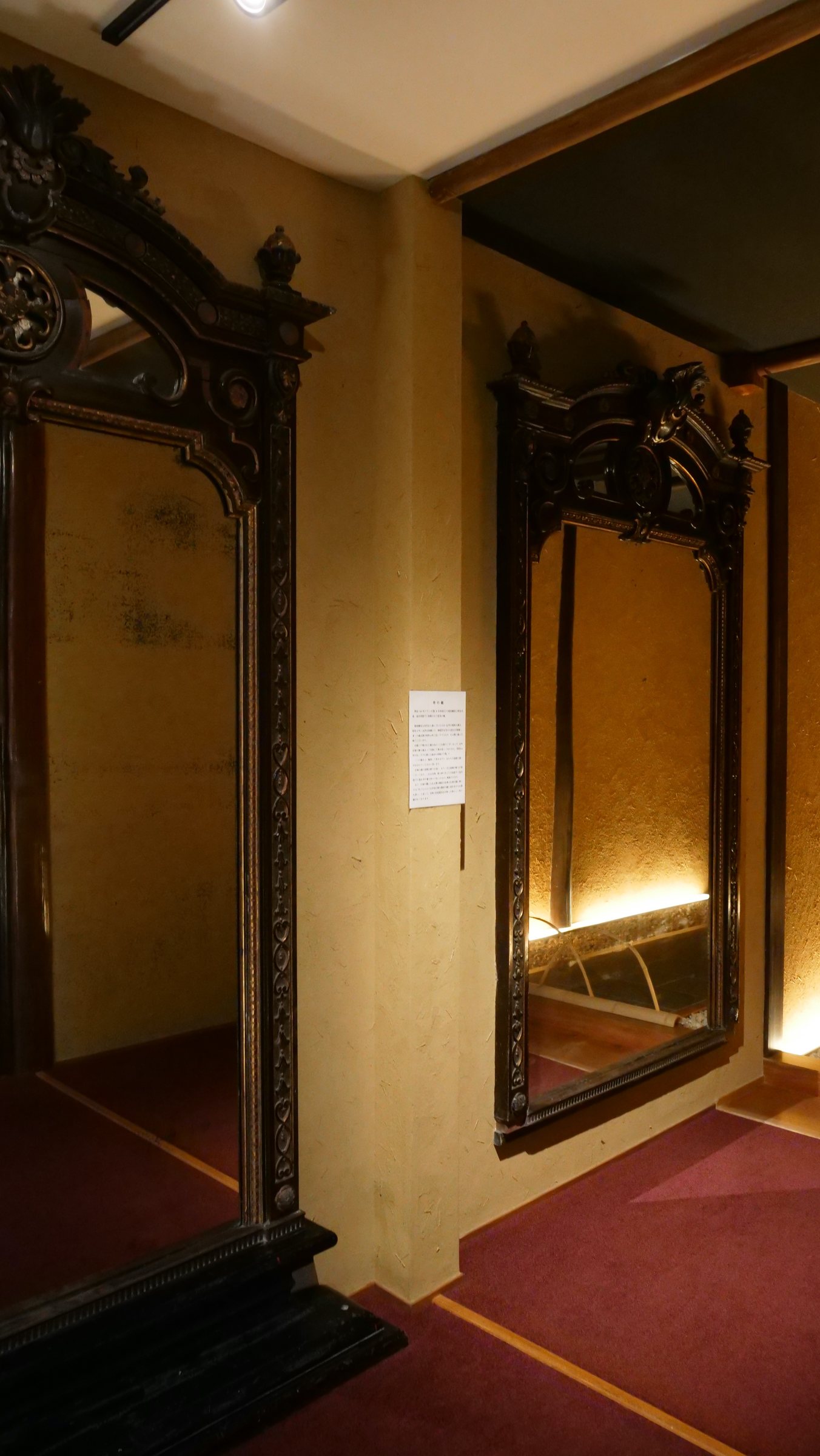 The Emperor Meiji's mirror, in its carved dark frame.