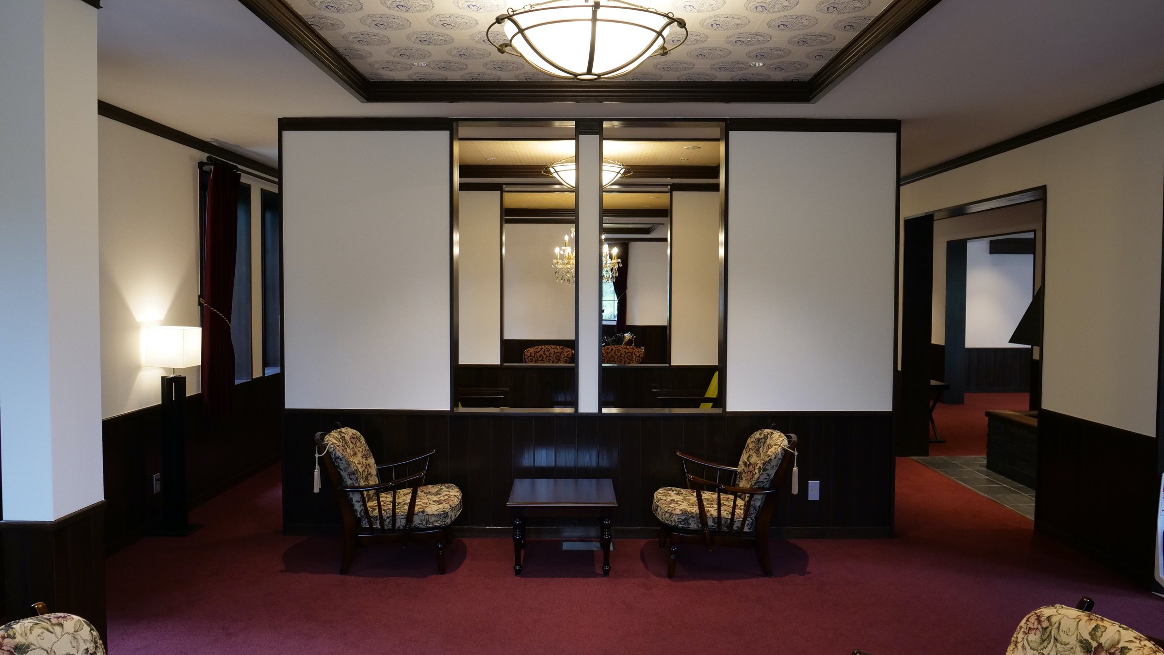 The lounge, with its curved ceiling light and dark wainscoting.