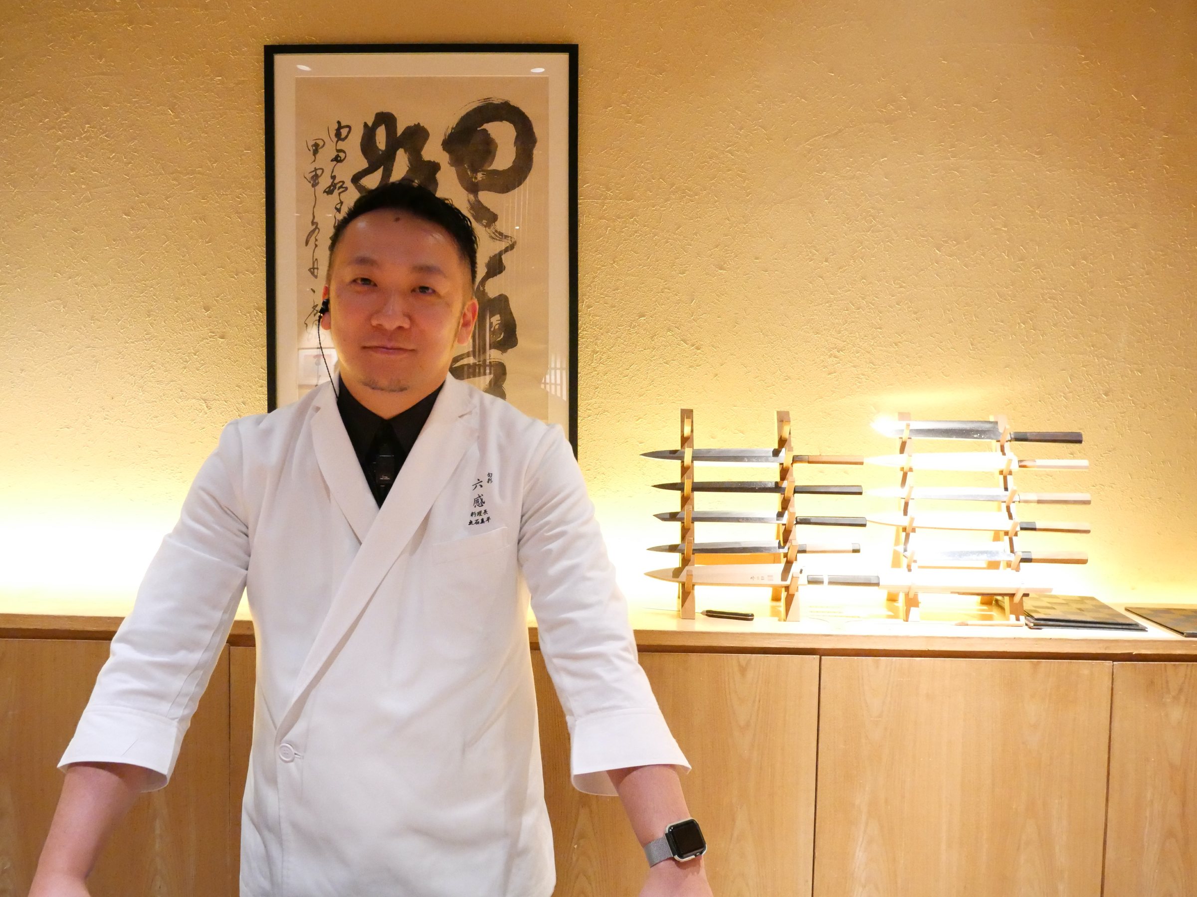 The head chef at the counter, in his white jacket.