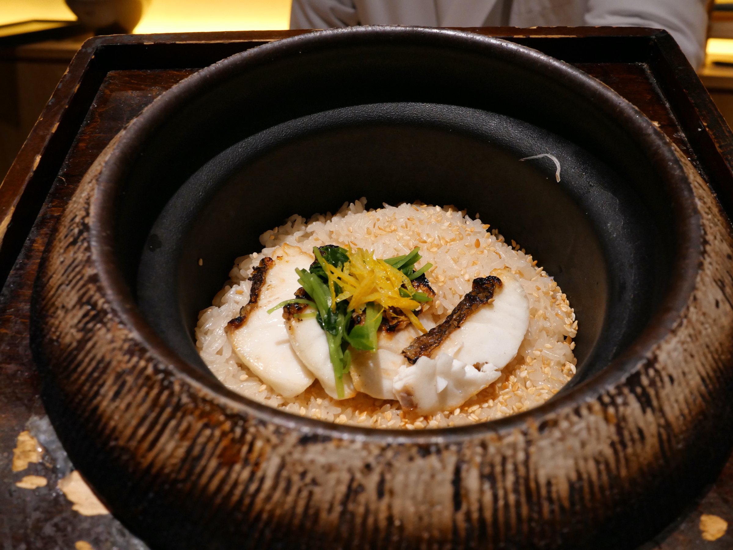 Kinmedai rice in its rough earthenware pot, topped with greens and yuzu.