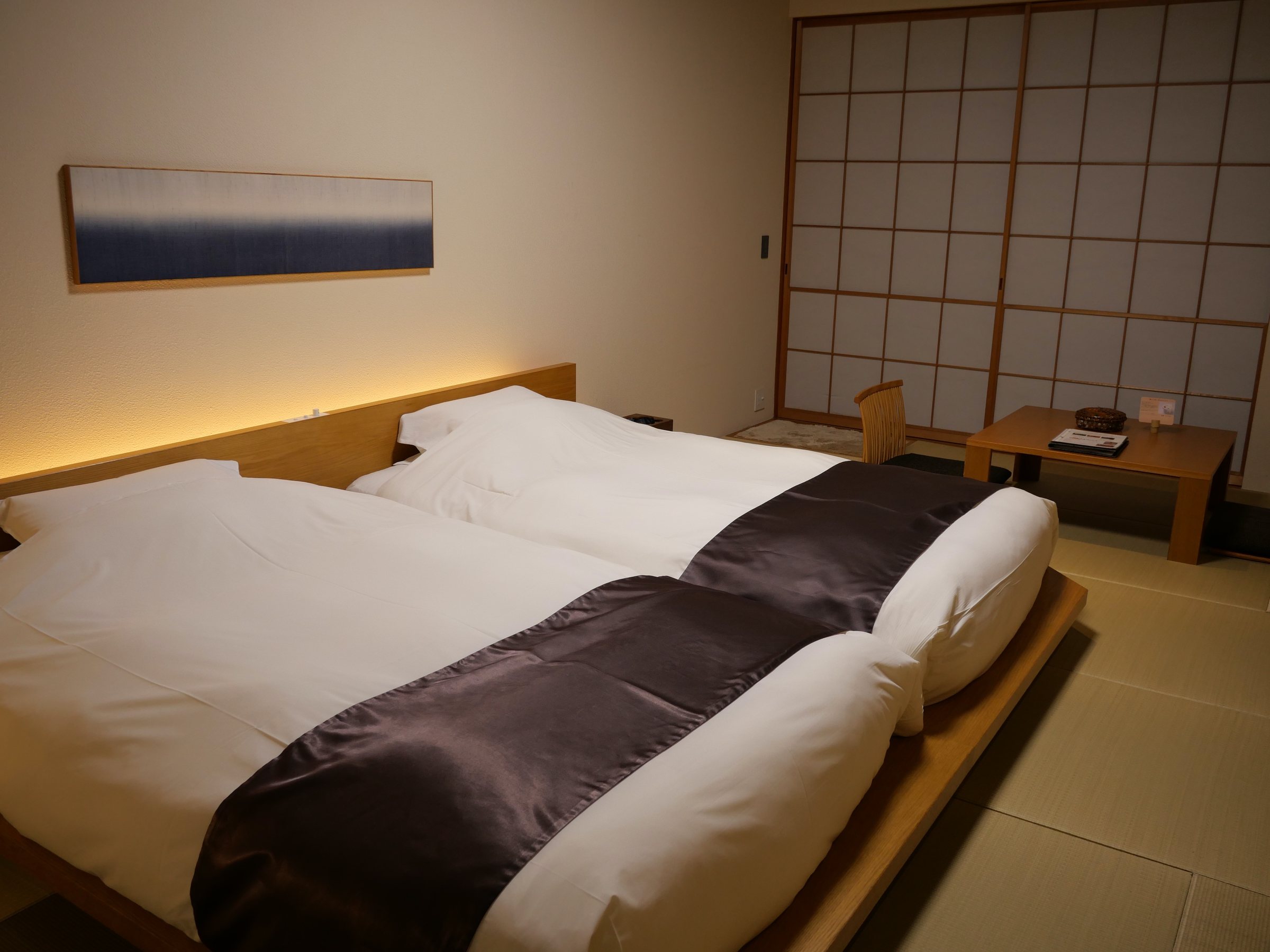 Twin beds on tatami, a long indigo print above.