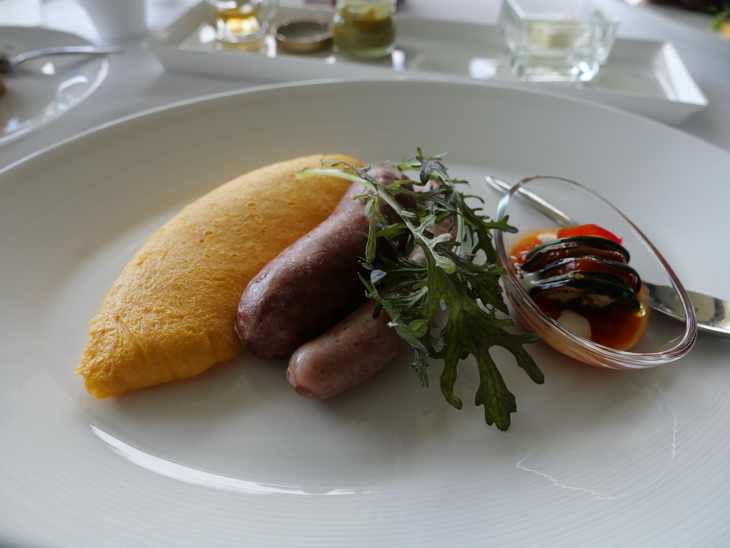 Omelet, game sausages and the eggplant-and-cheese garnish.