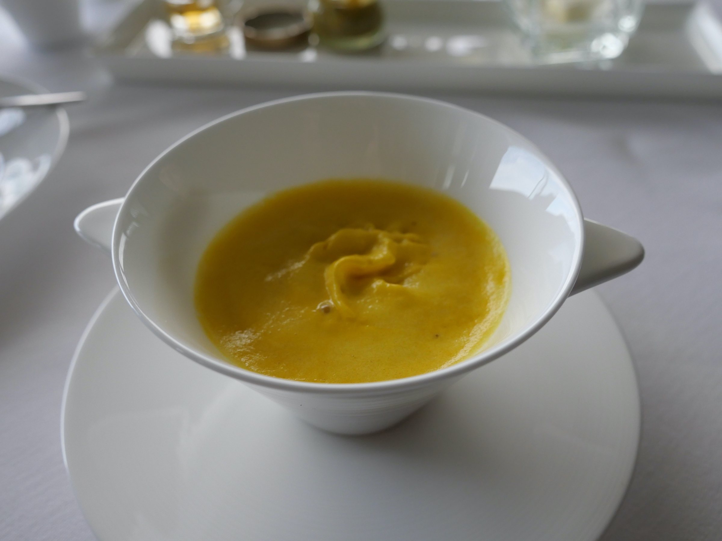 Yellow pepper espuma in a white cup.