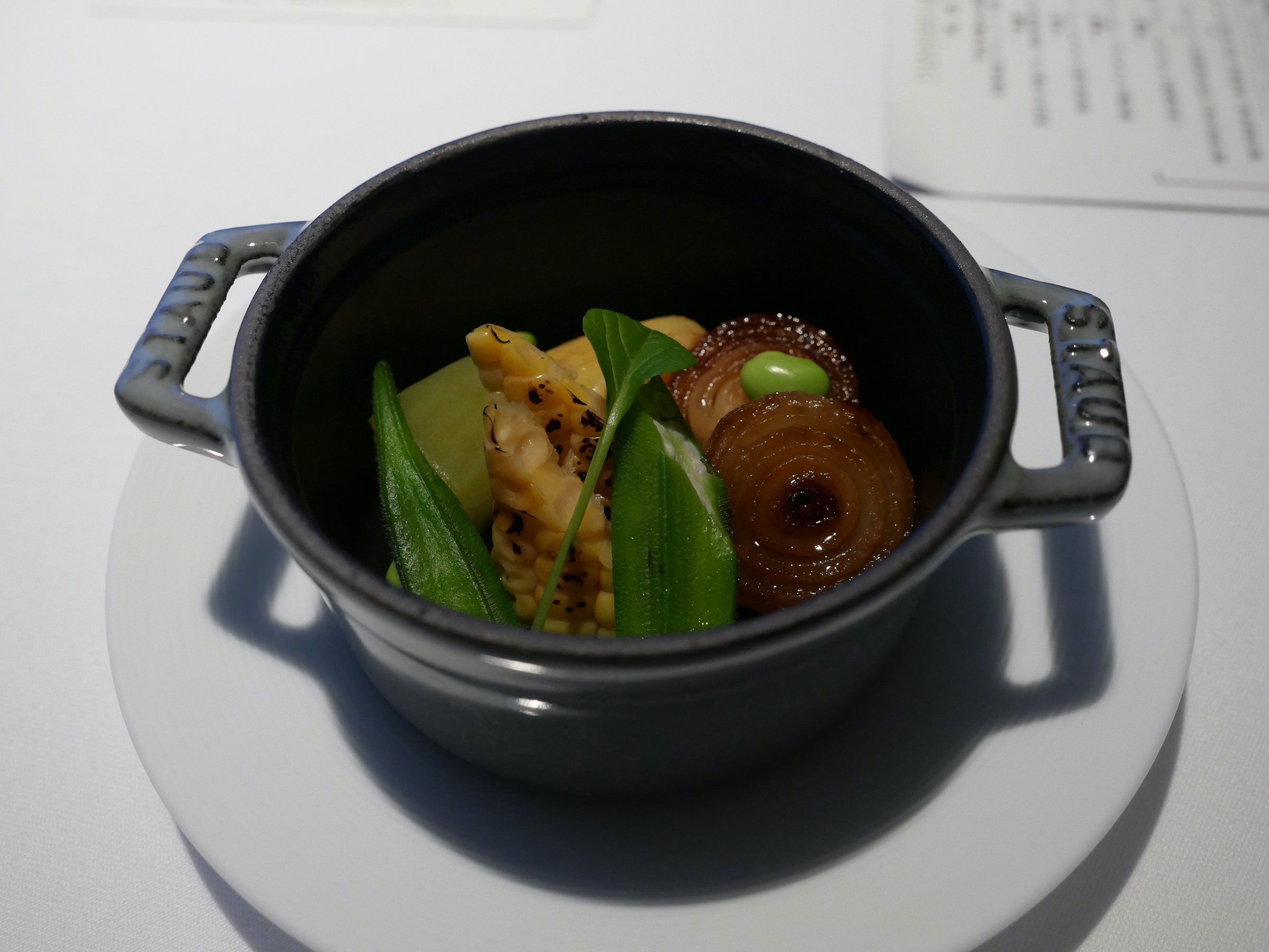 Vegetables roasted in a small cast-iron cocotte.