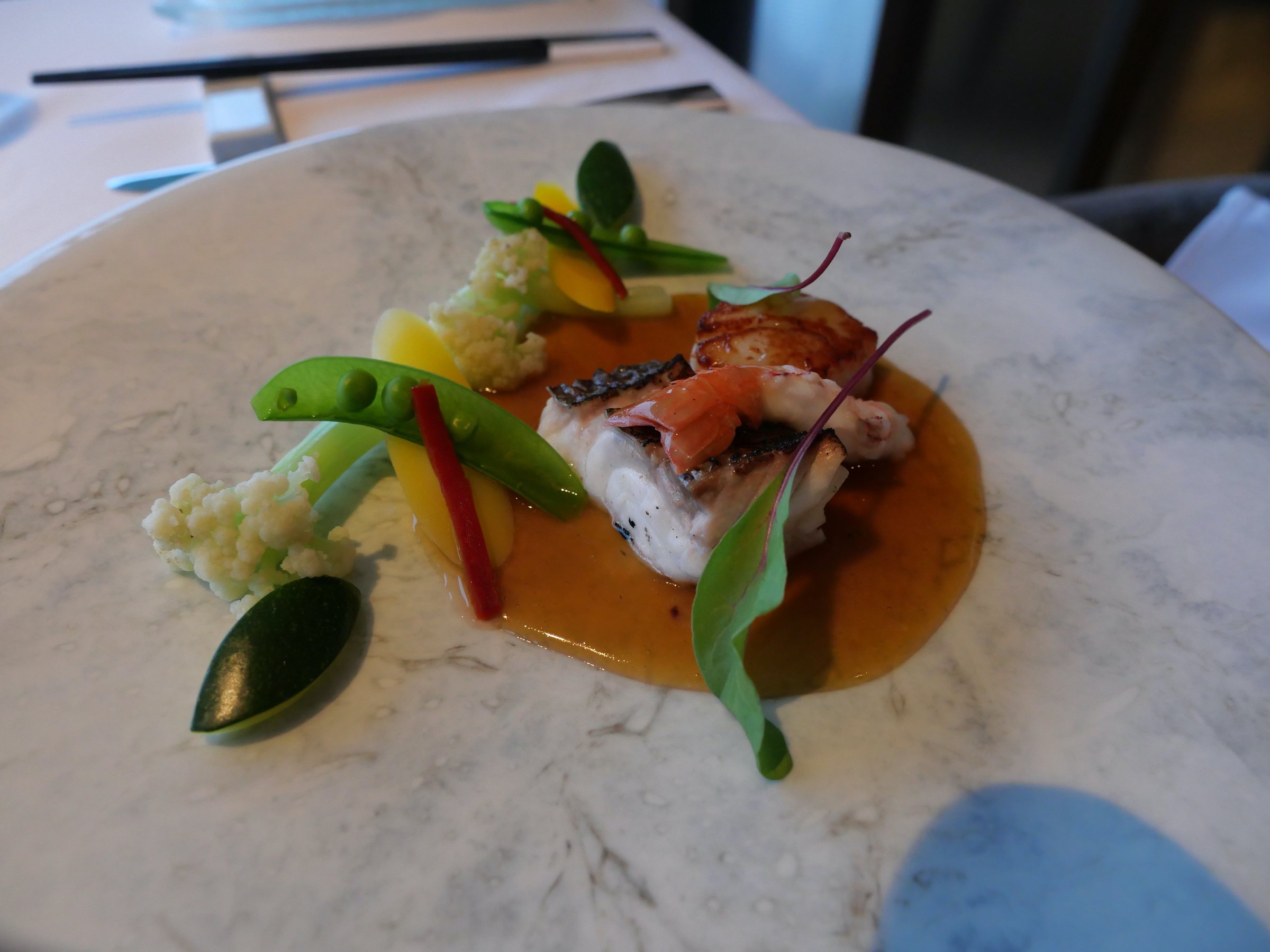 The seafood ensemble with colorful vegetables, on a marble plate.