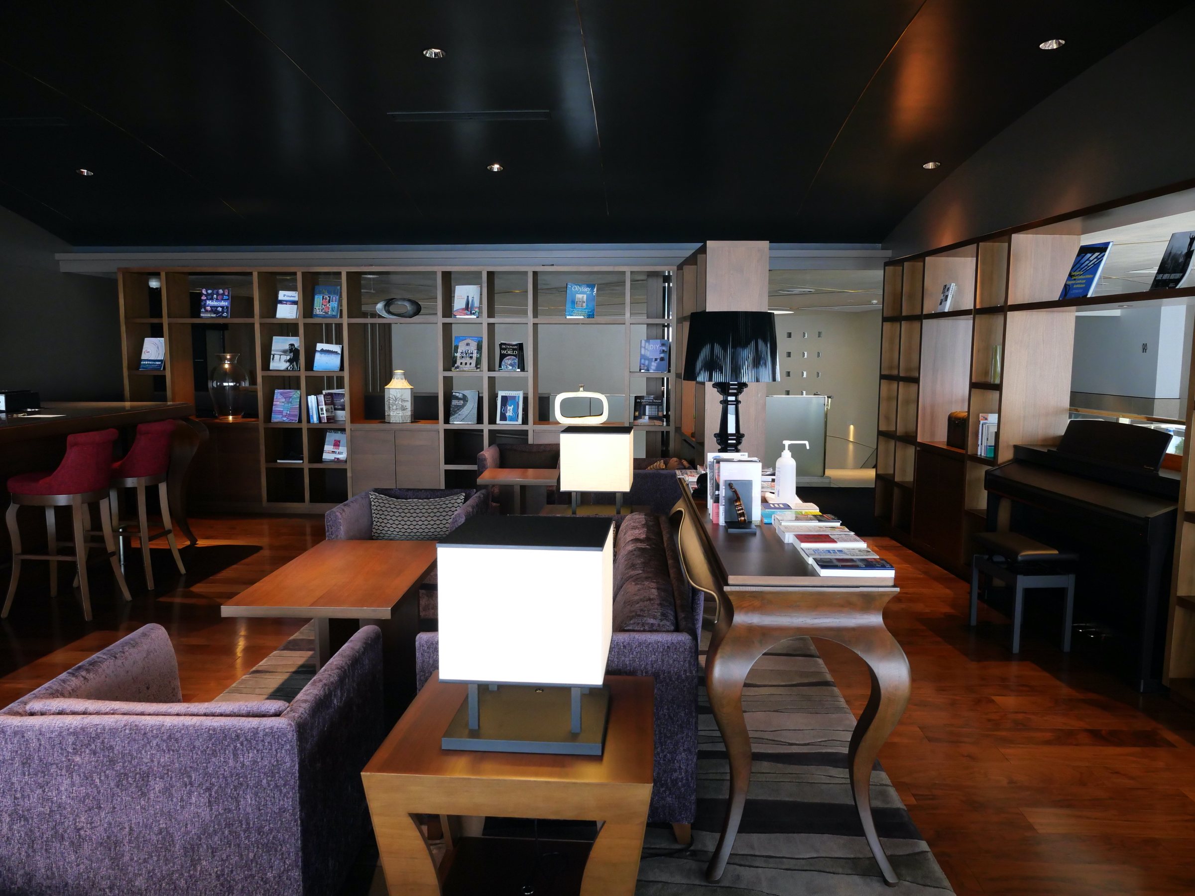 The lounge, with its sofas, bookshelves and a piano.