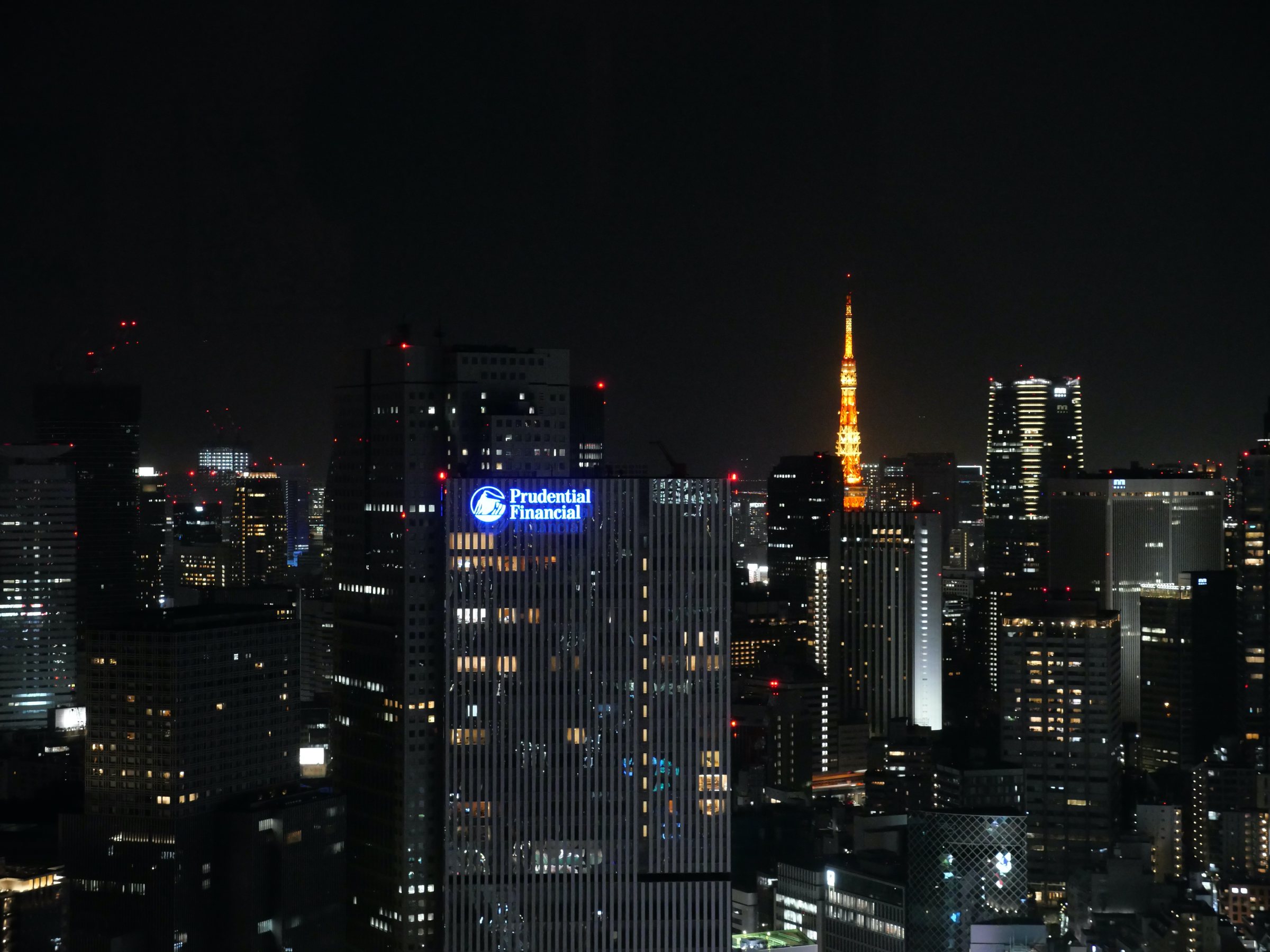 Tokyo Tower glowing among the lit towers.