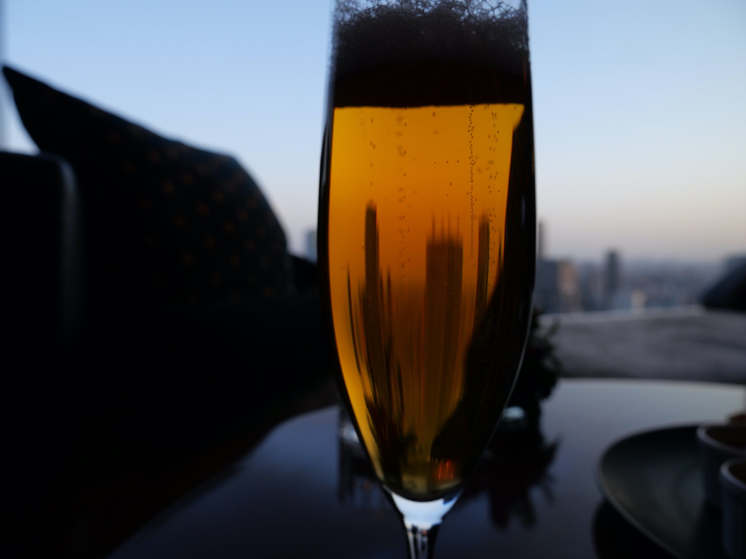 A glass of beer against the evening sky.