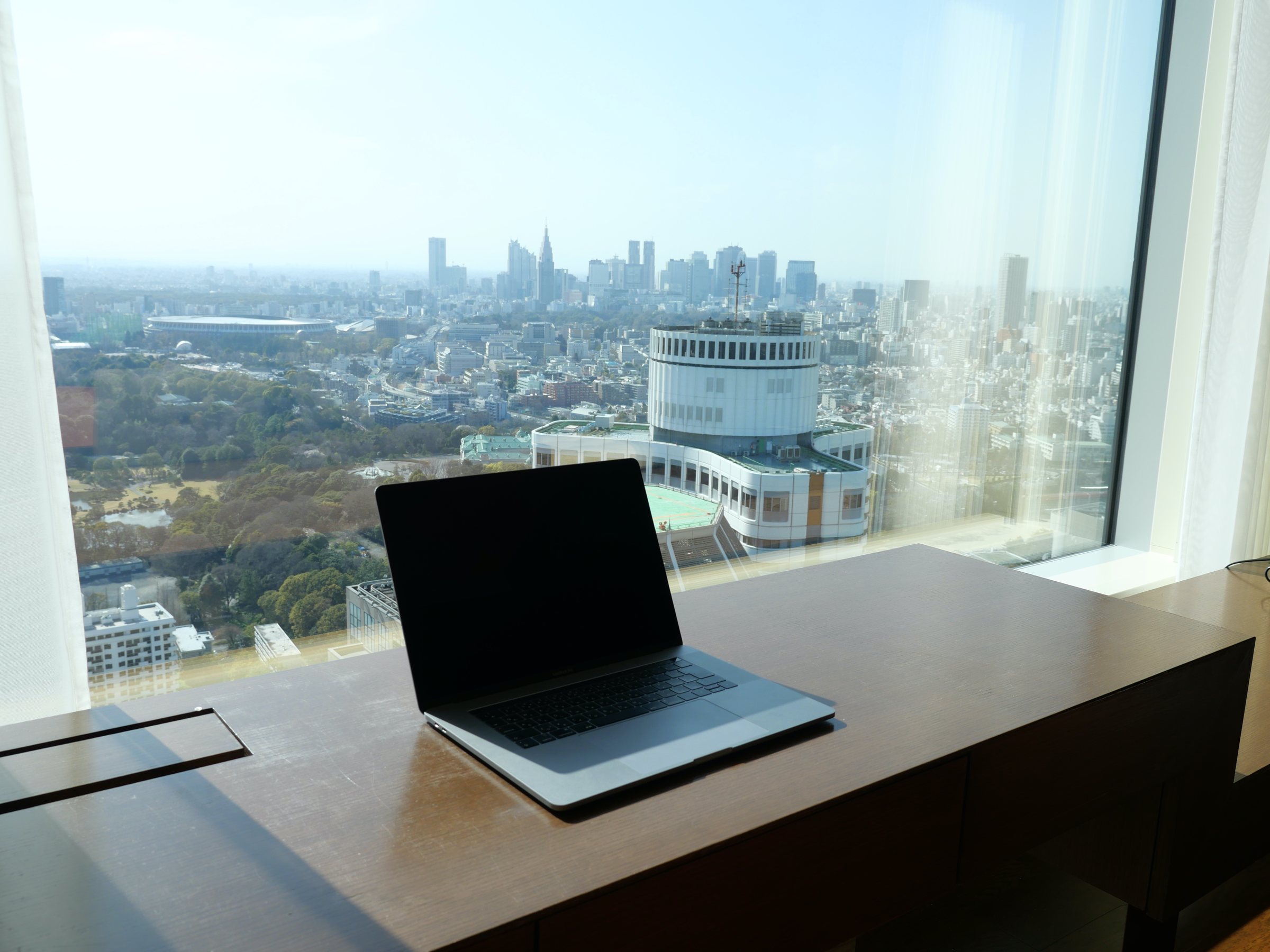 A desk by the window, with the city spread below.