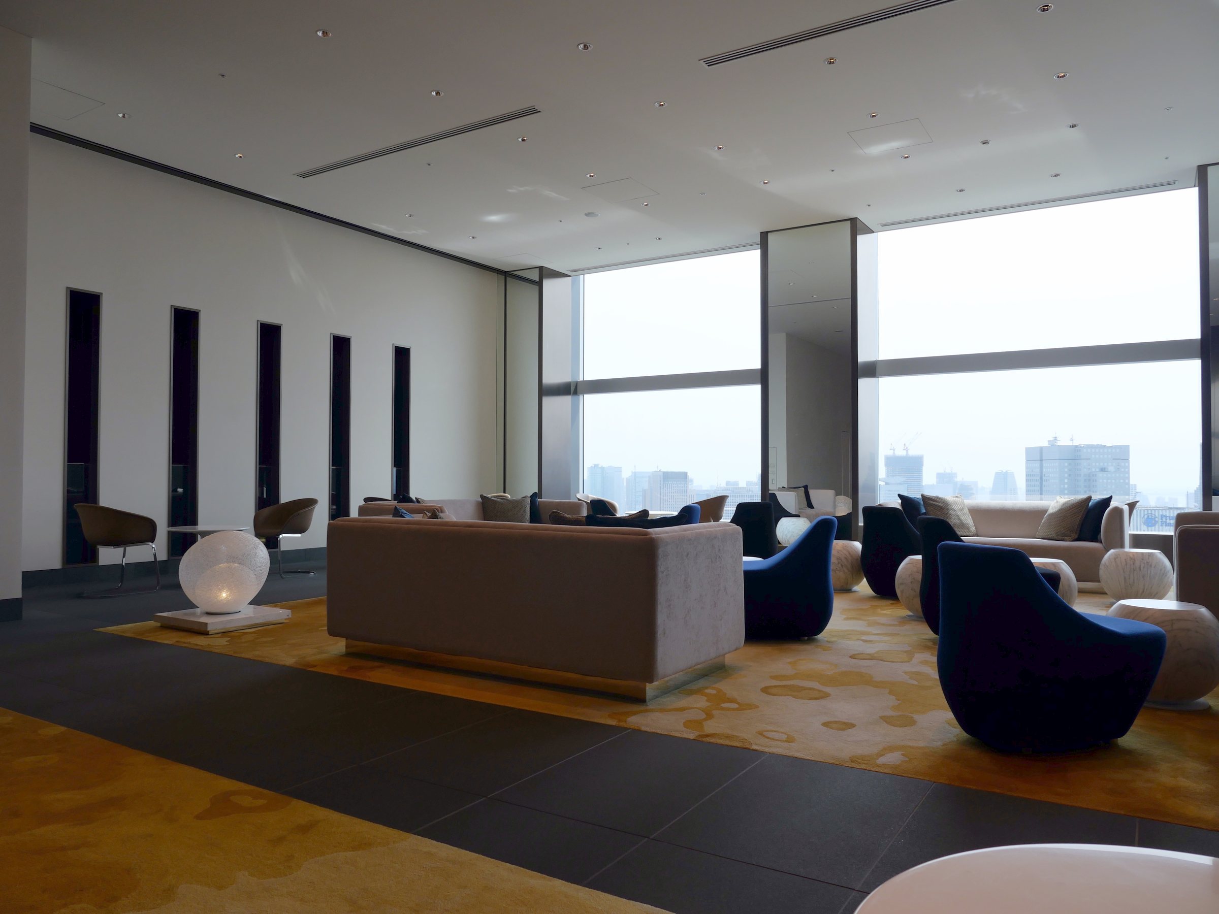 The entrance hall: low sofas and tall windows onto the city.