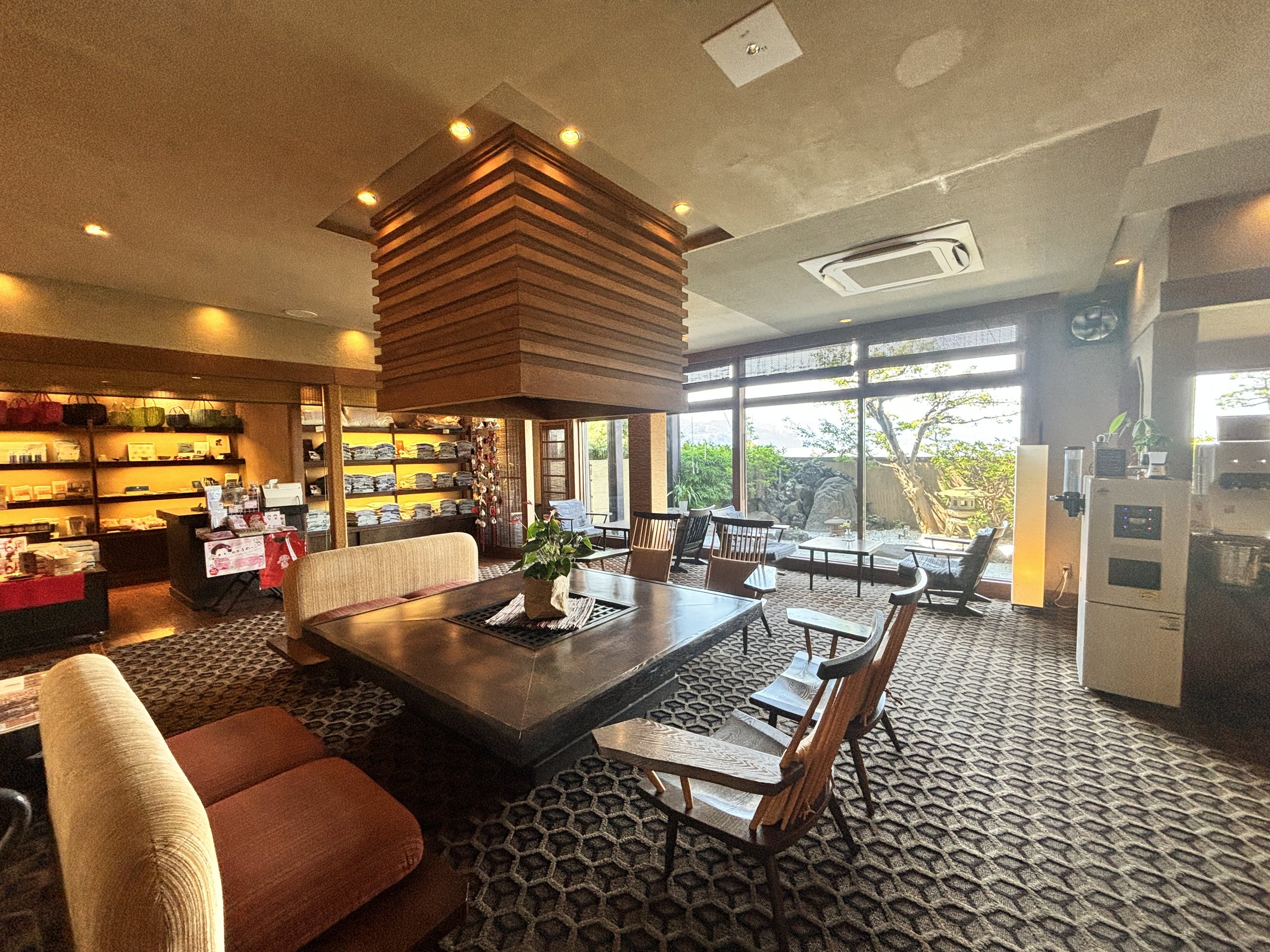 The lobby lounge, with the shop shelves on the left and the sea beyond the windows.