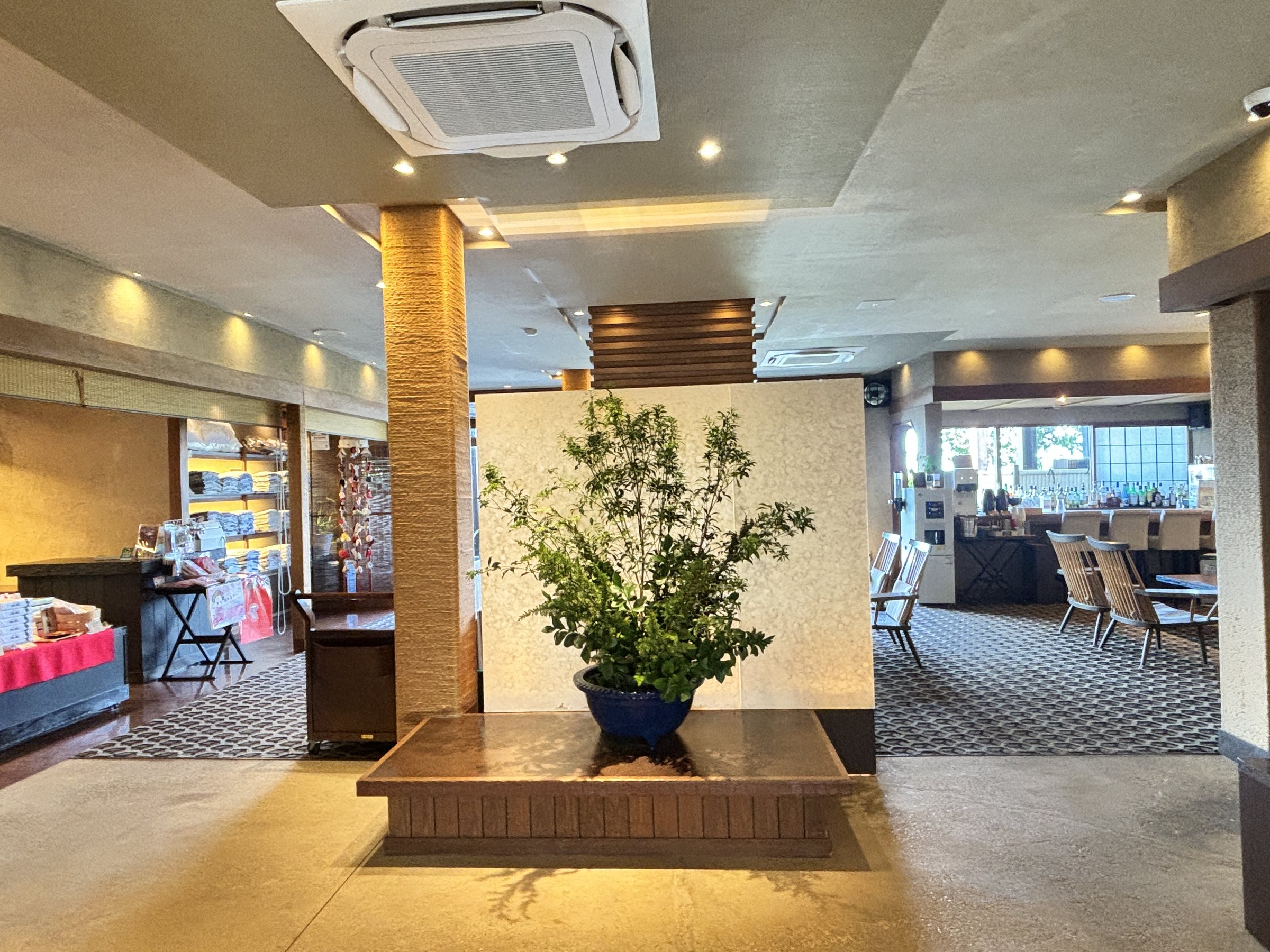 A large arrangement of greenery on a wooden plinth in the lobby.