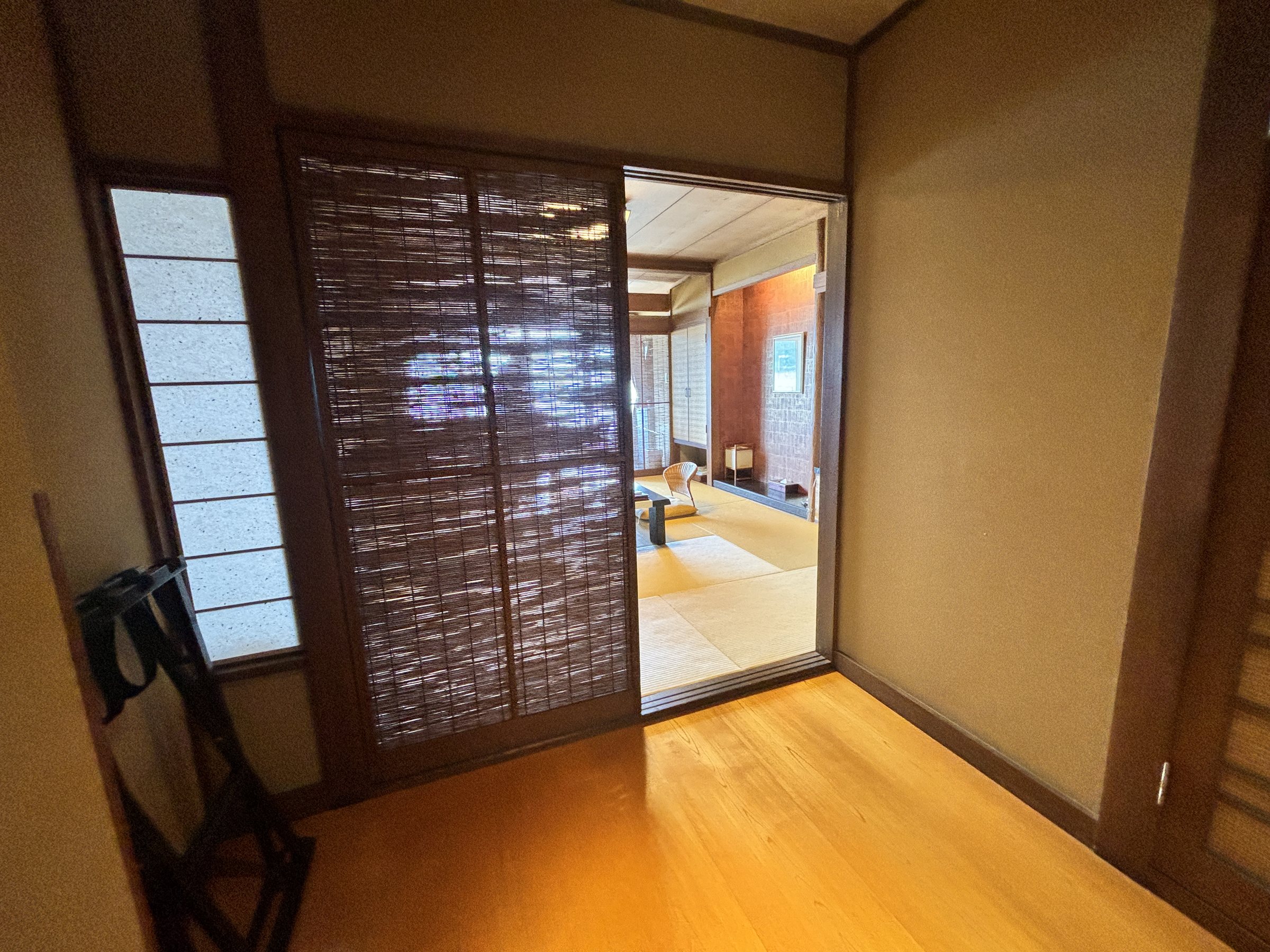 The entrance to the room, with a reed-blind screen and the tatami room beyond.