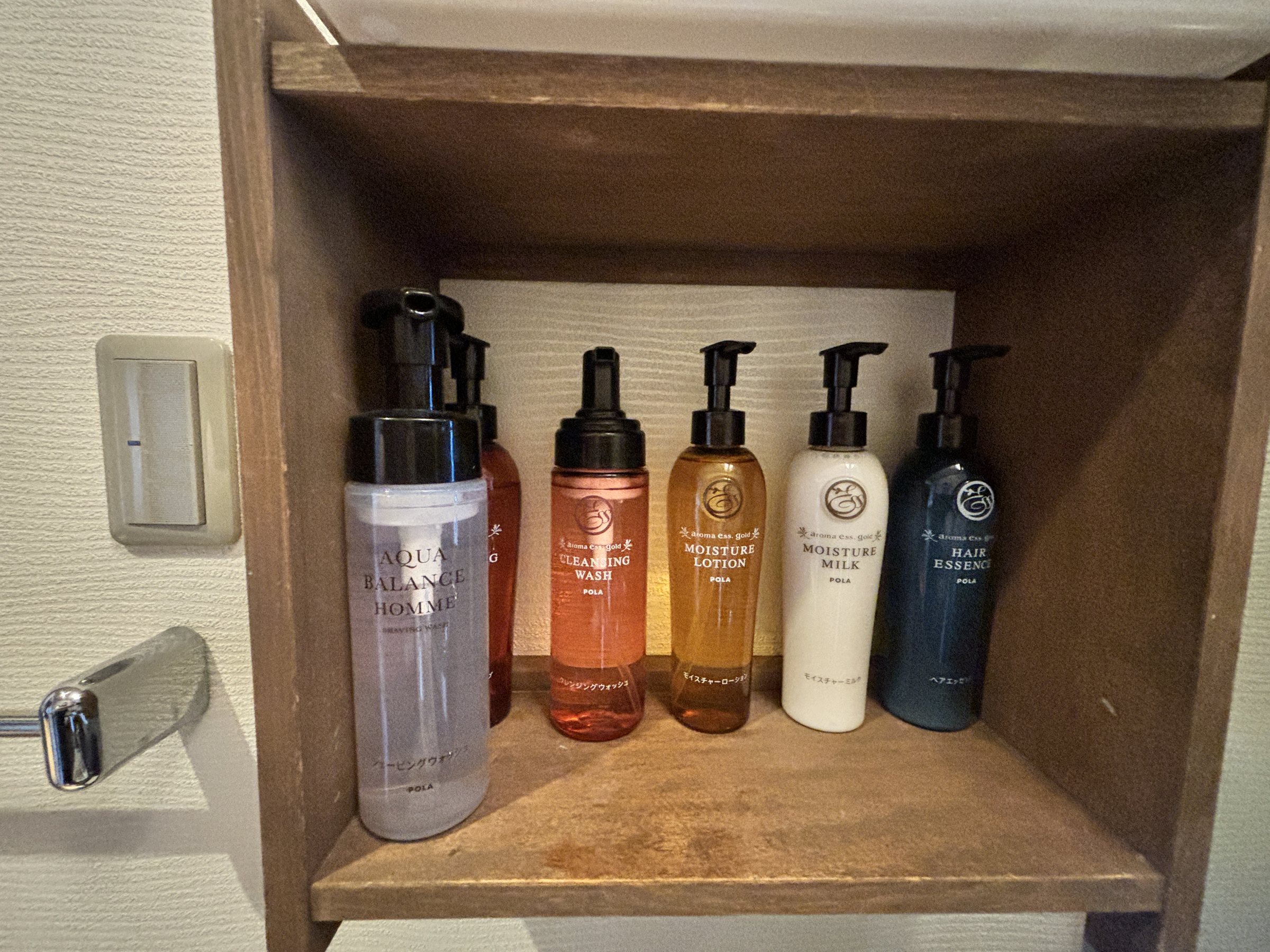 POLA amenities lined up on a wooden shelf.