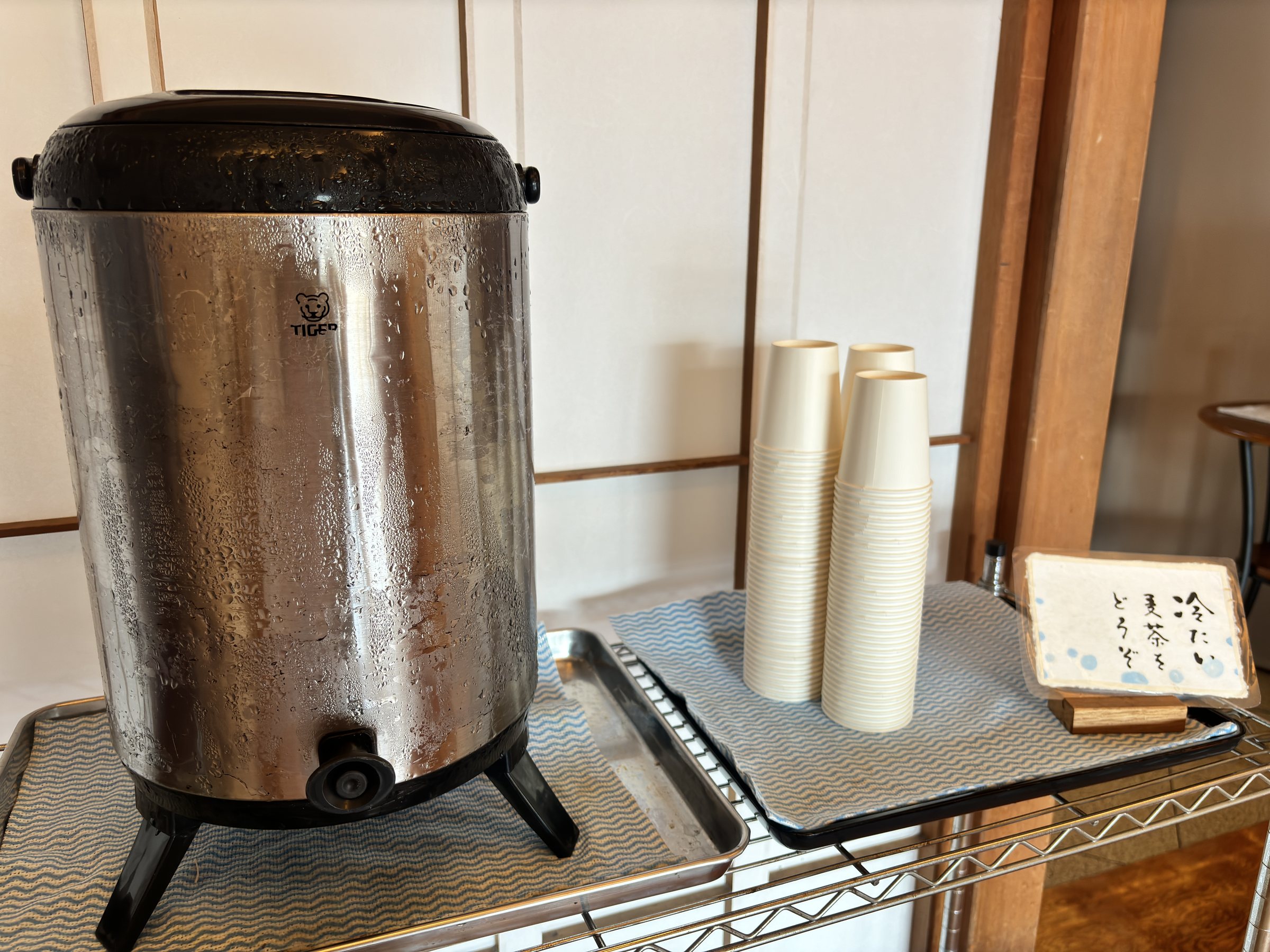 A stainless-steel urn of cold barley tea in the rest area.