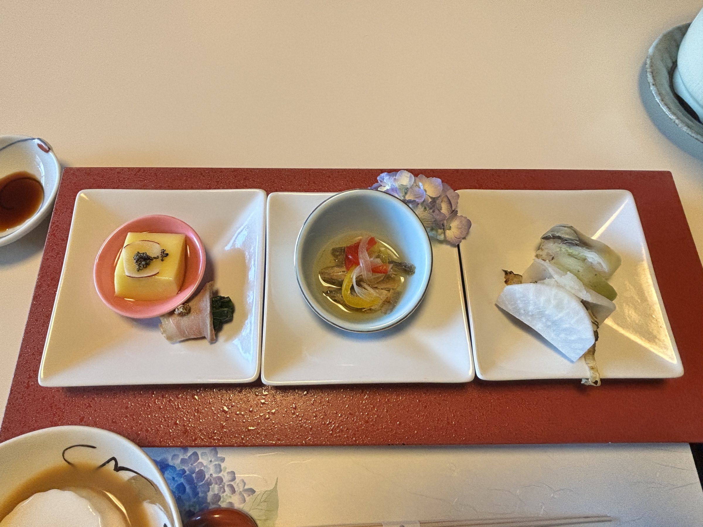 The appetisers, set out in three dishes on a red tray.