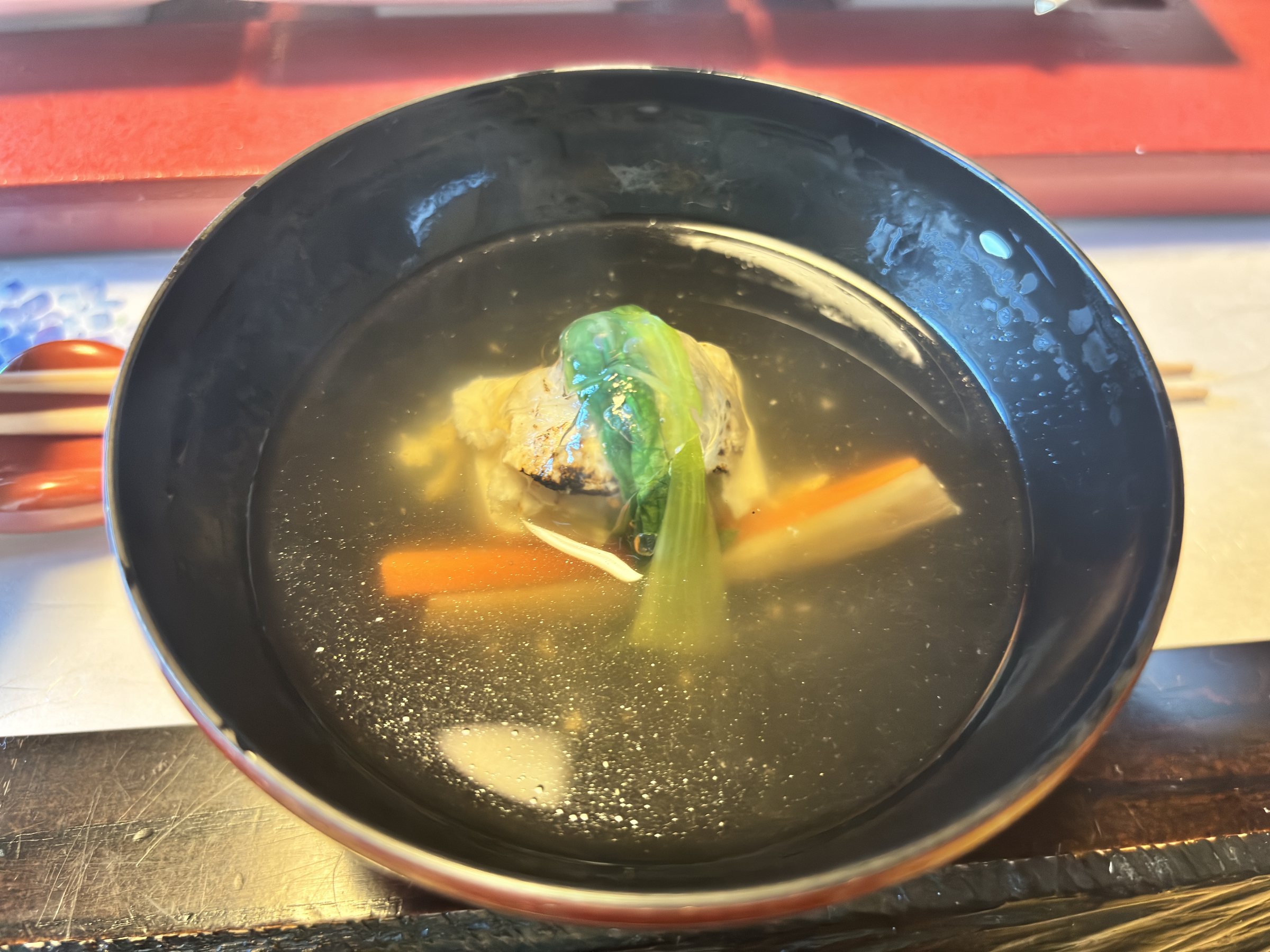 Clear soup with greens and carrot.