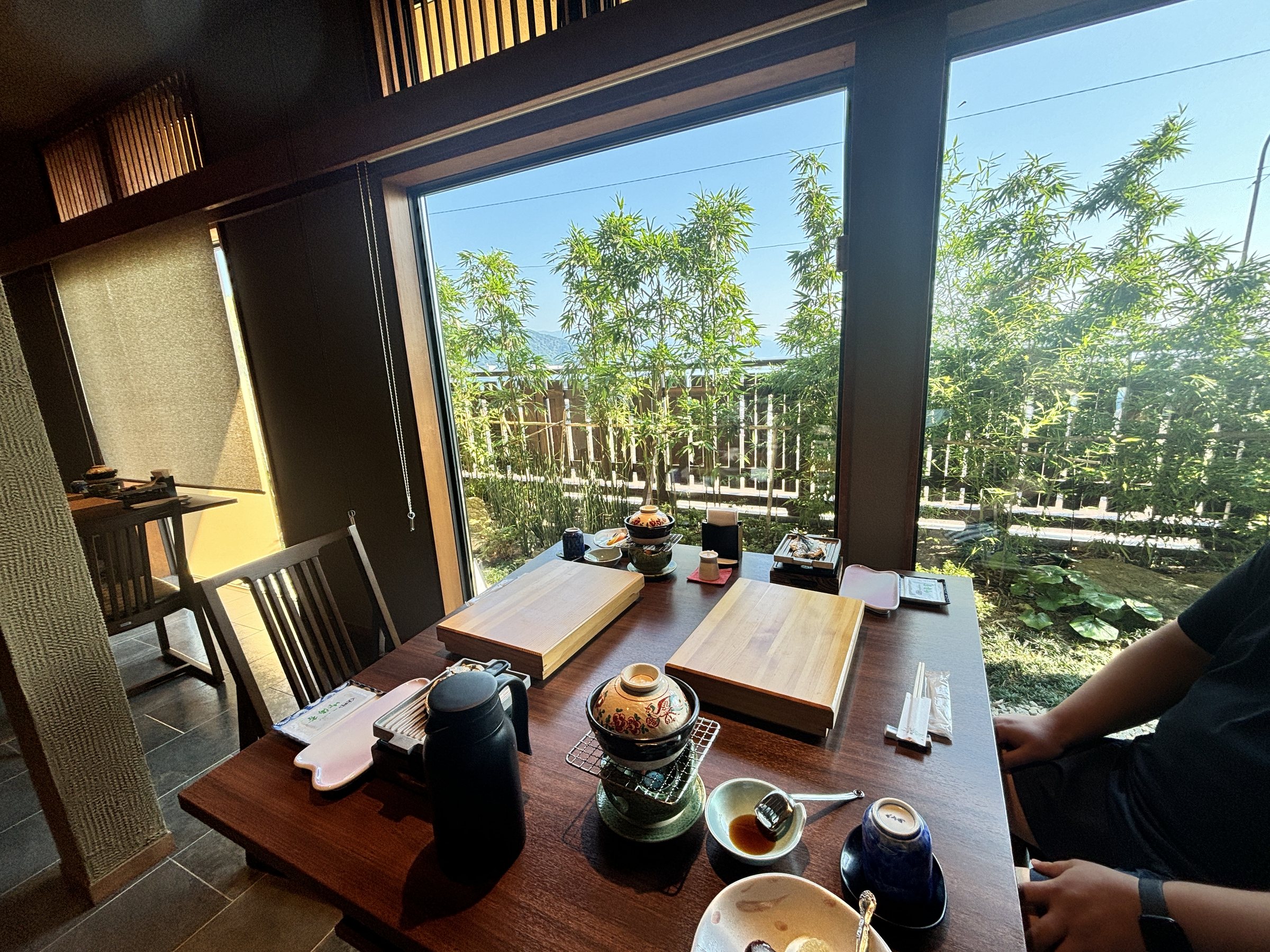 The breakfast table by the window, with greenery outside.
