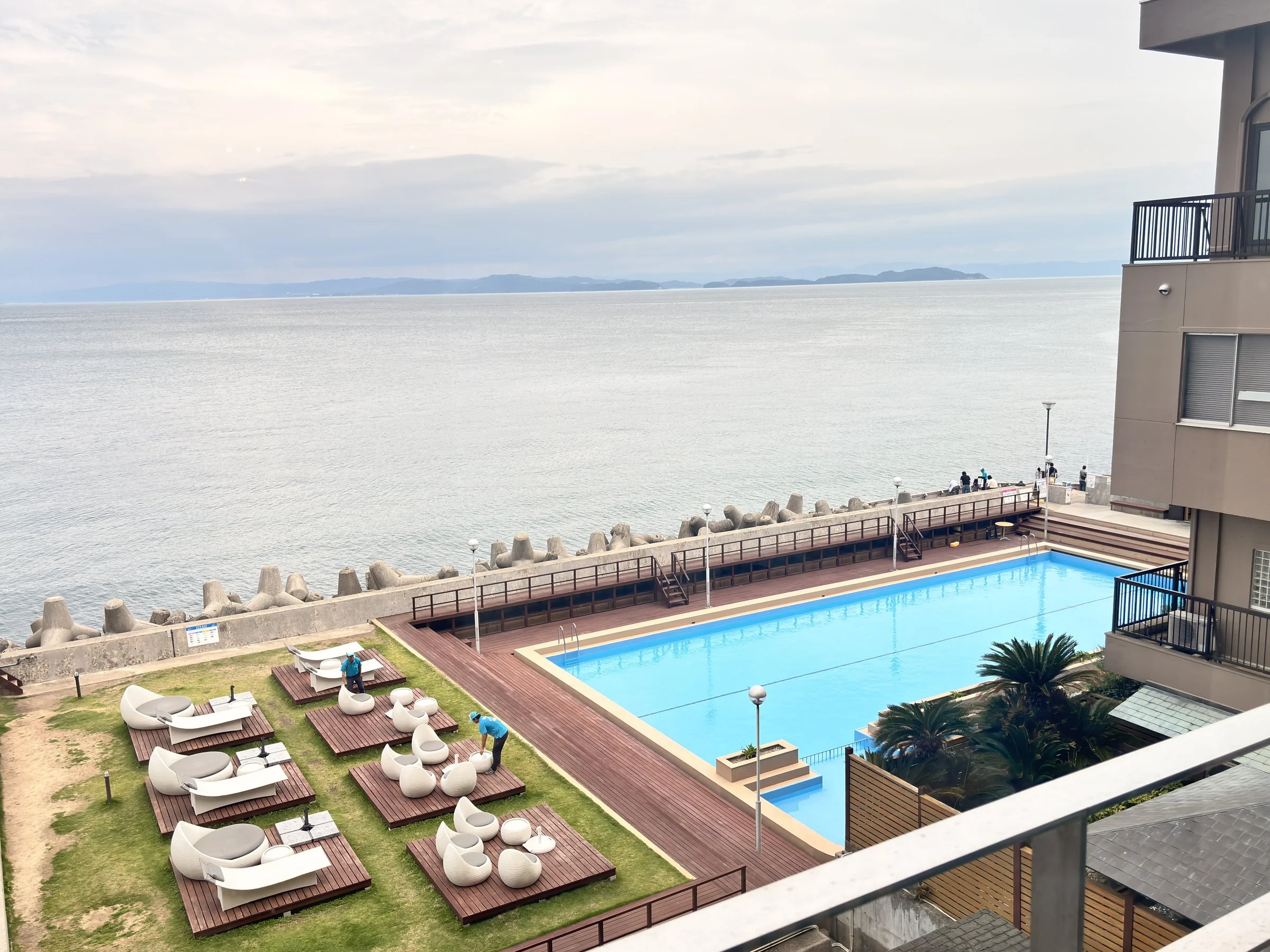 The pool and its sun loungers on the lawn, right above the sea wall.