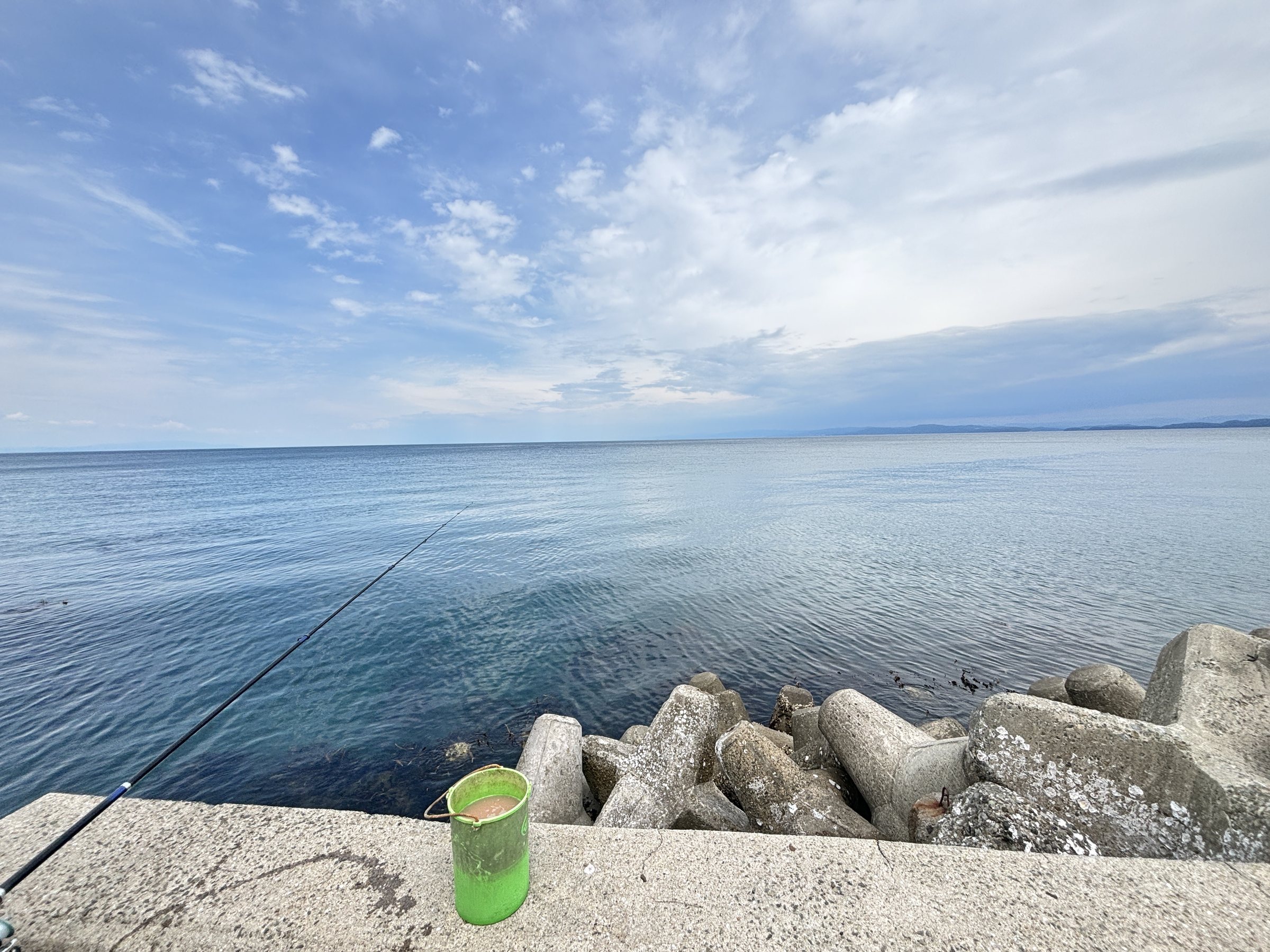 A rod over the sea wall on a bright, breezy afternoon.