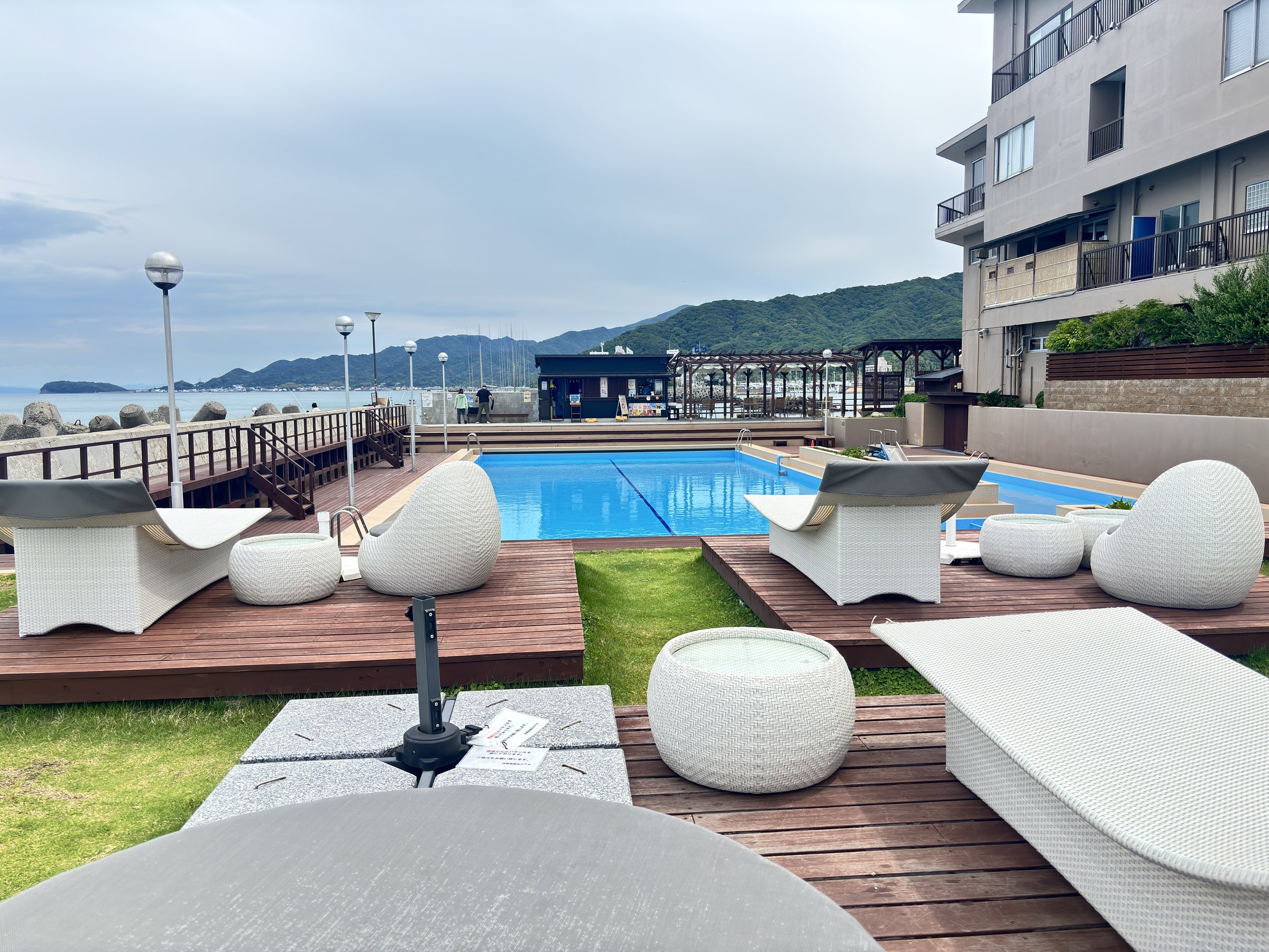 The pool terrace with its white loungers and seats.