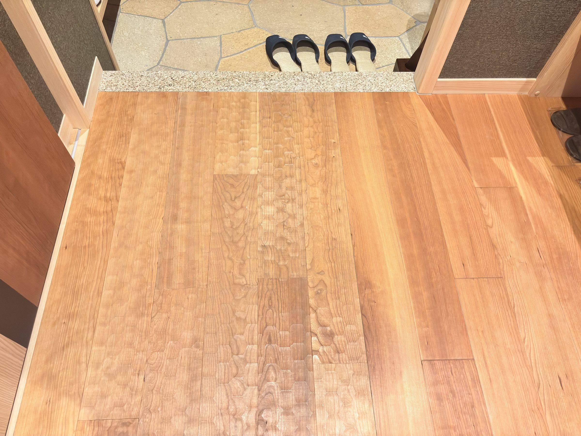 Wooden flooring with a spoon-cut finish at the entrance.