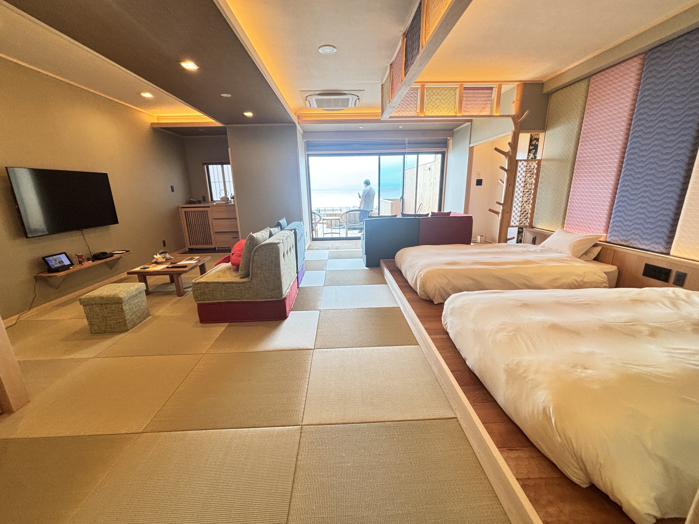 Beds on a raised tatami platform, with the sea beyond.