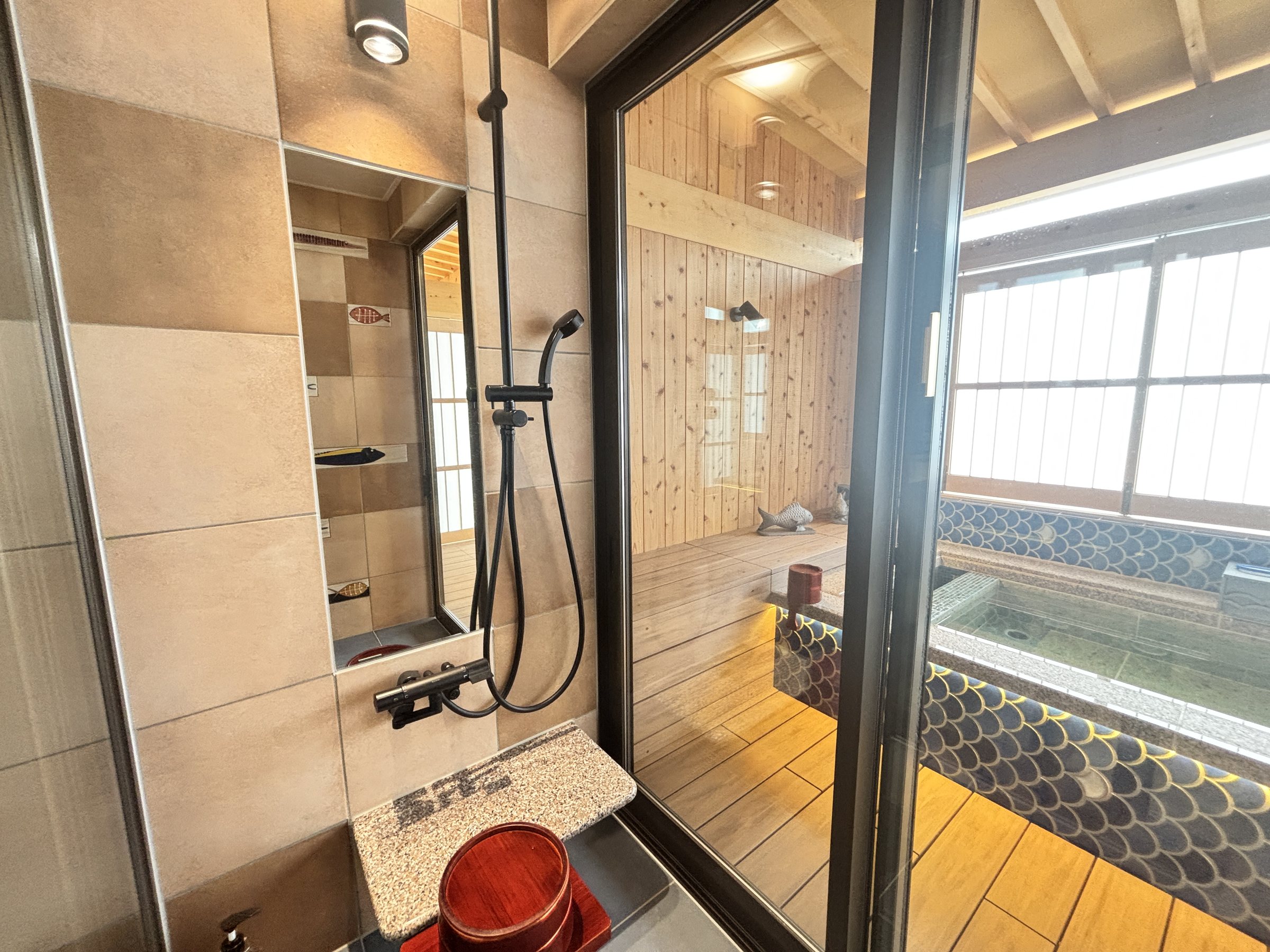 The shower area, with the bath beyond the glass.