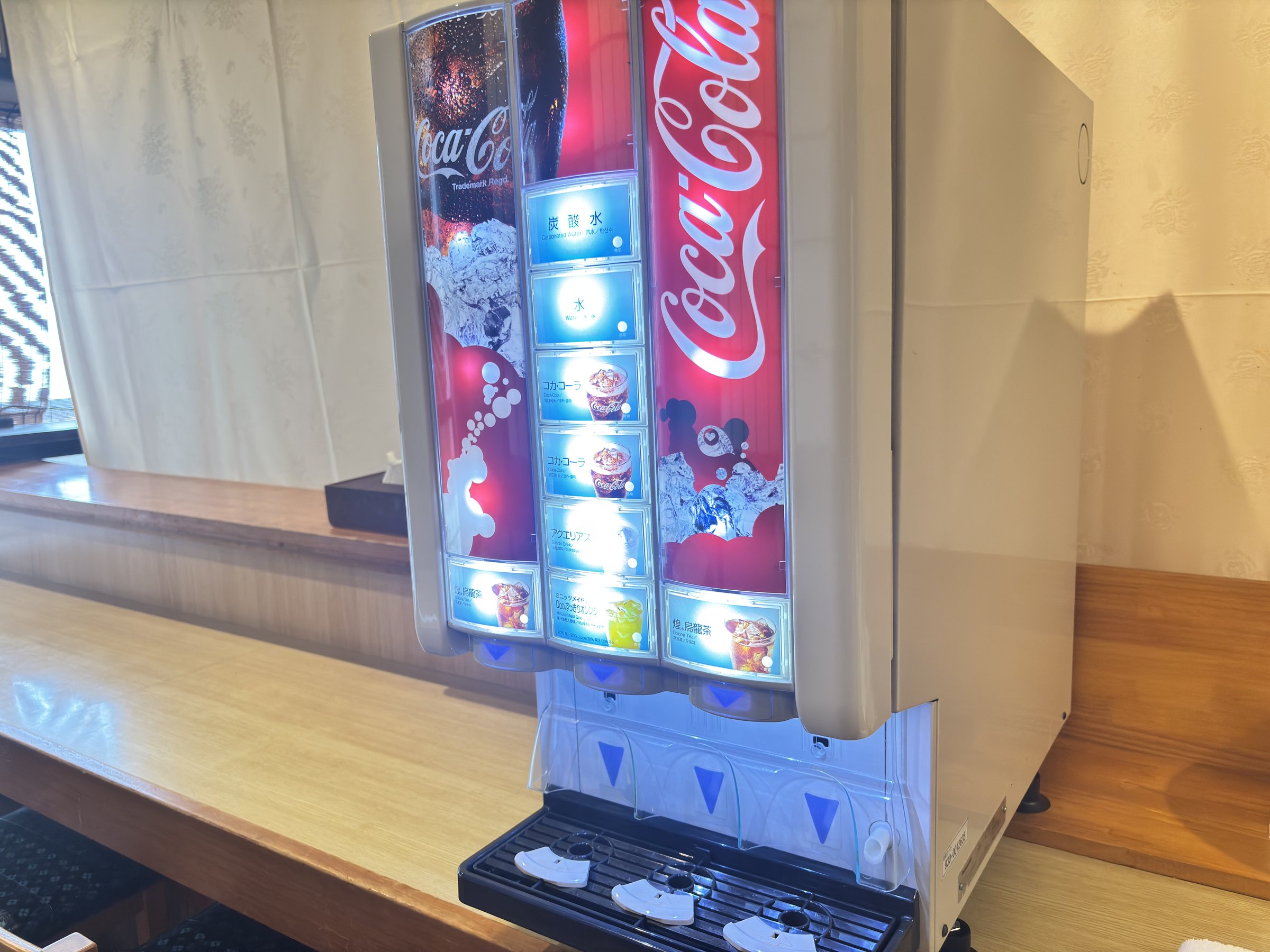 A soft-drink dispenser near the baths.