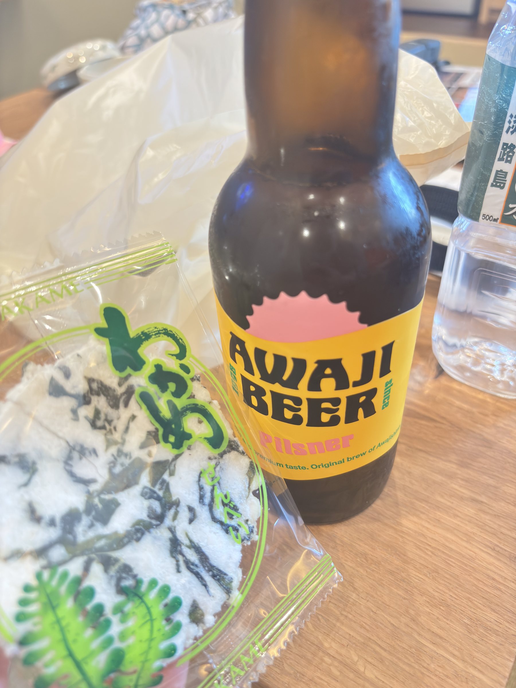 A bottle of Awaji Beer beside a packet of local snacks.