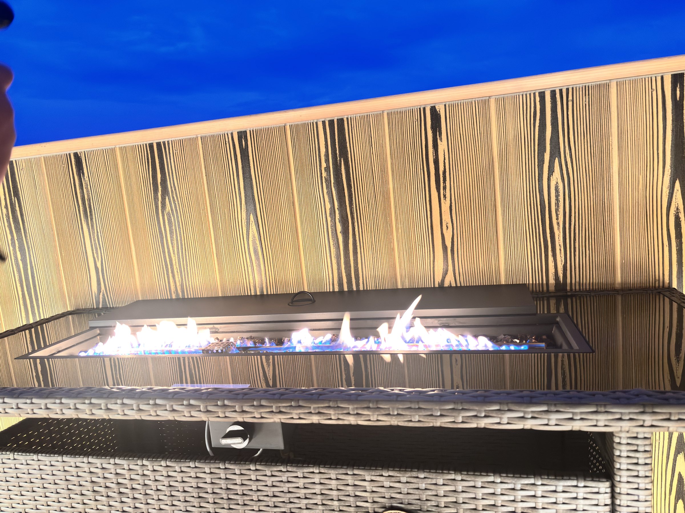 Real flames in the balcony fire table at dusk.