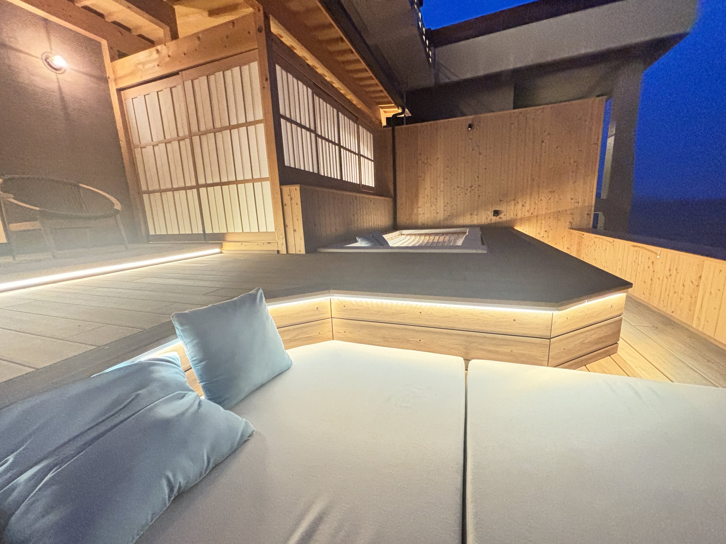 The lit daybed on the balcony after dark.