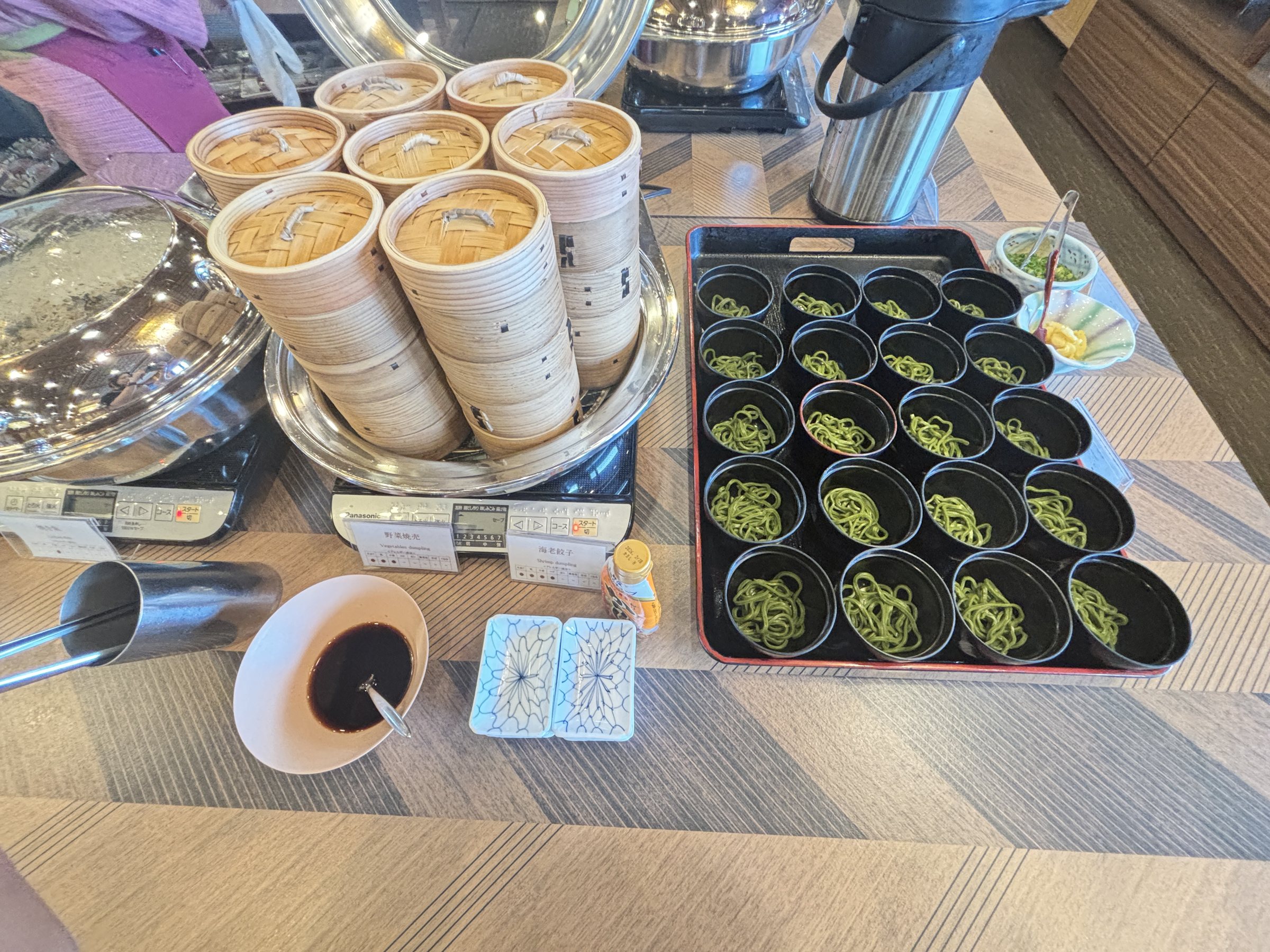 Bamboo steamers and small cups of greens.