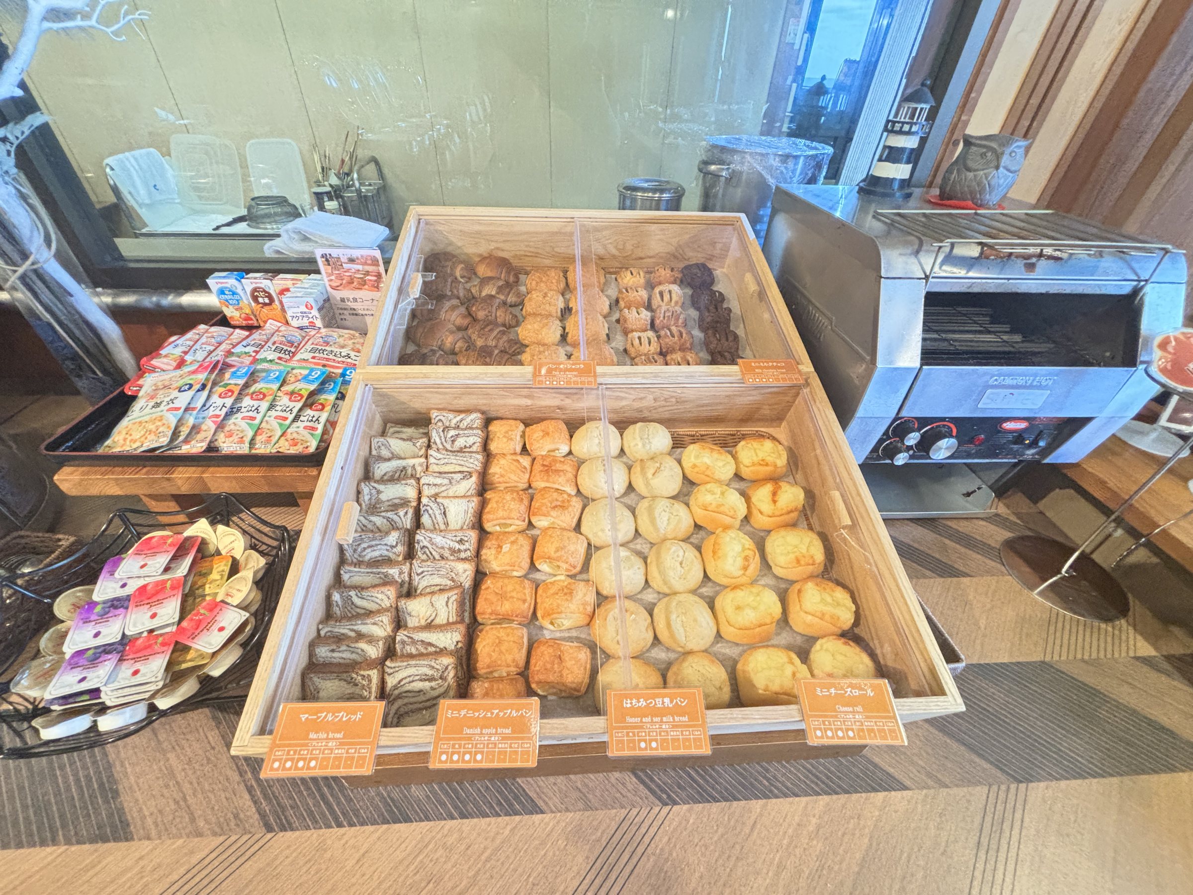Breads and pastries laid out beside a conveyor toaster.