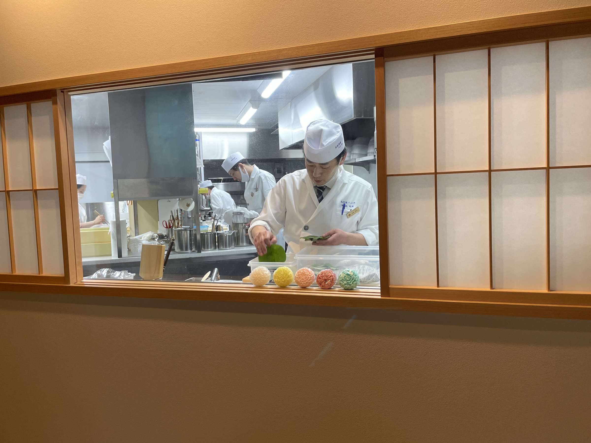 Through a window, a chef at work in the kitchen.