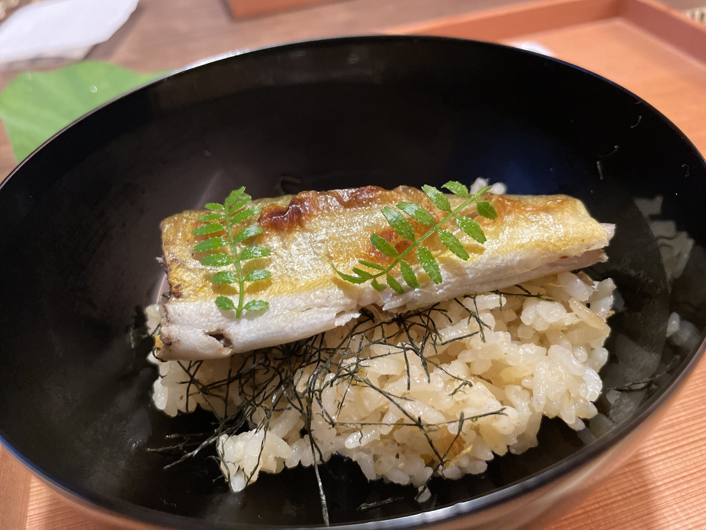 Ayu laid over steamed rice, with a garnish of green leaves.